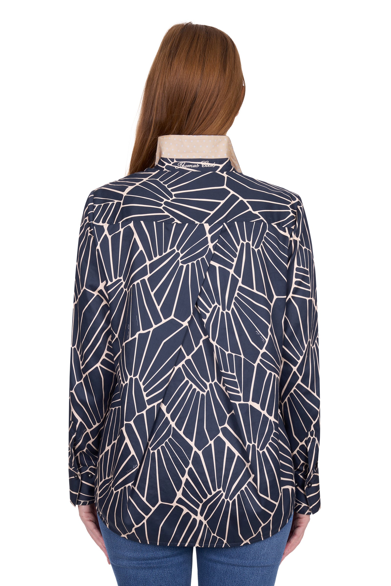 Woman wearing a navy blue geometric patterned shirt on a white background