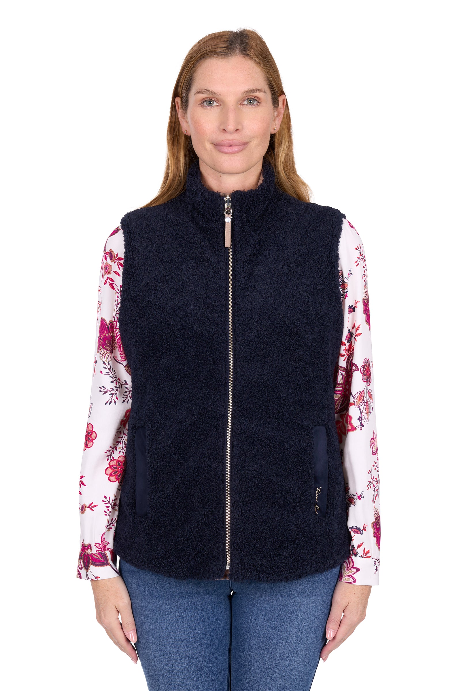 Woman wearing a navy blue vest over a floral shirt on a white background