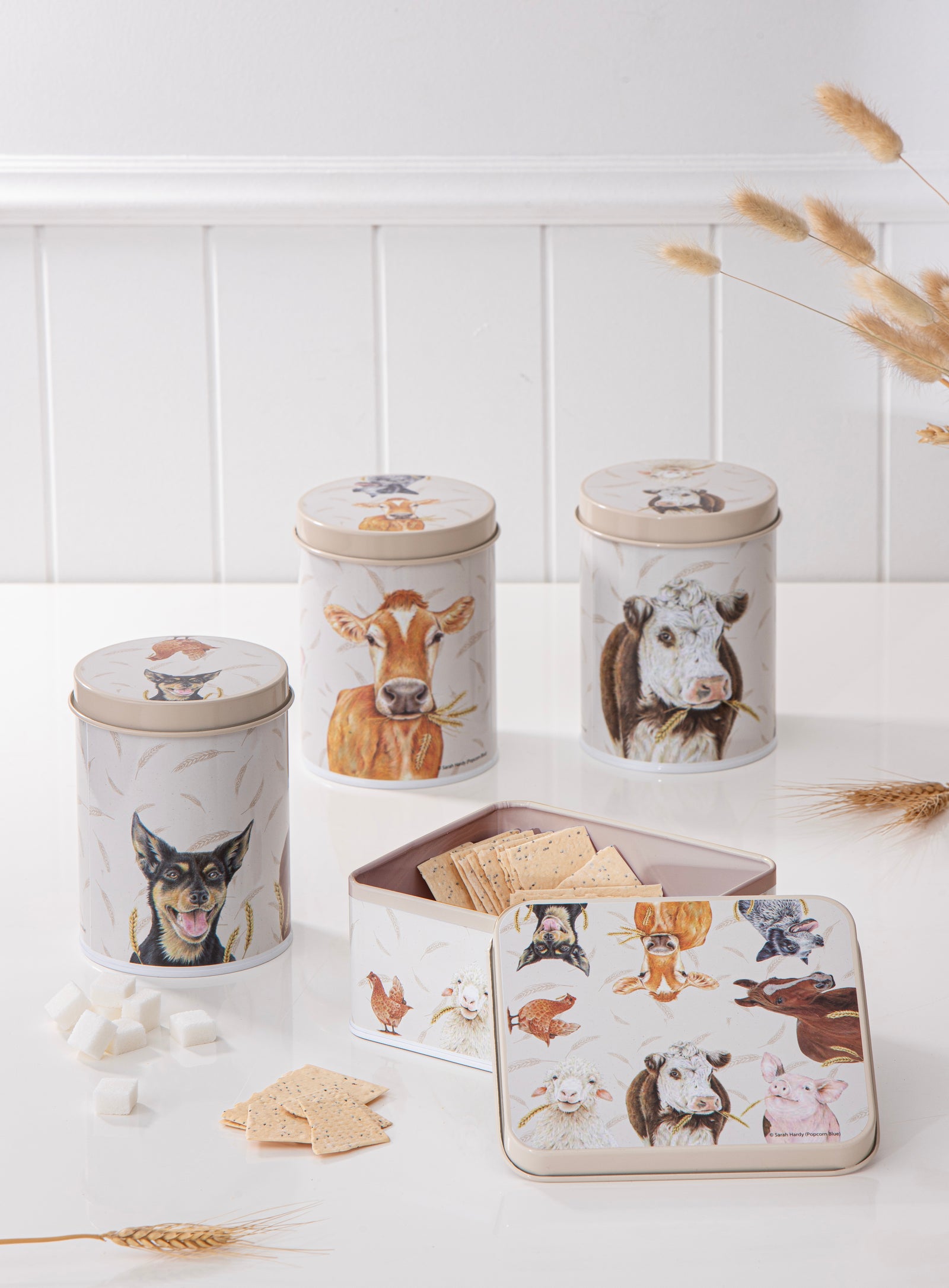 Set of decorative animal-themed storage jars on a white surface with a white wall background.