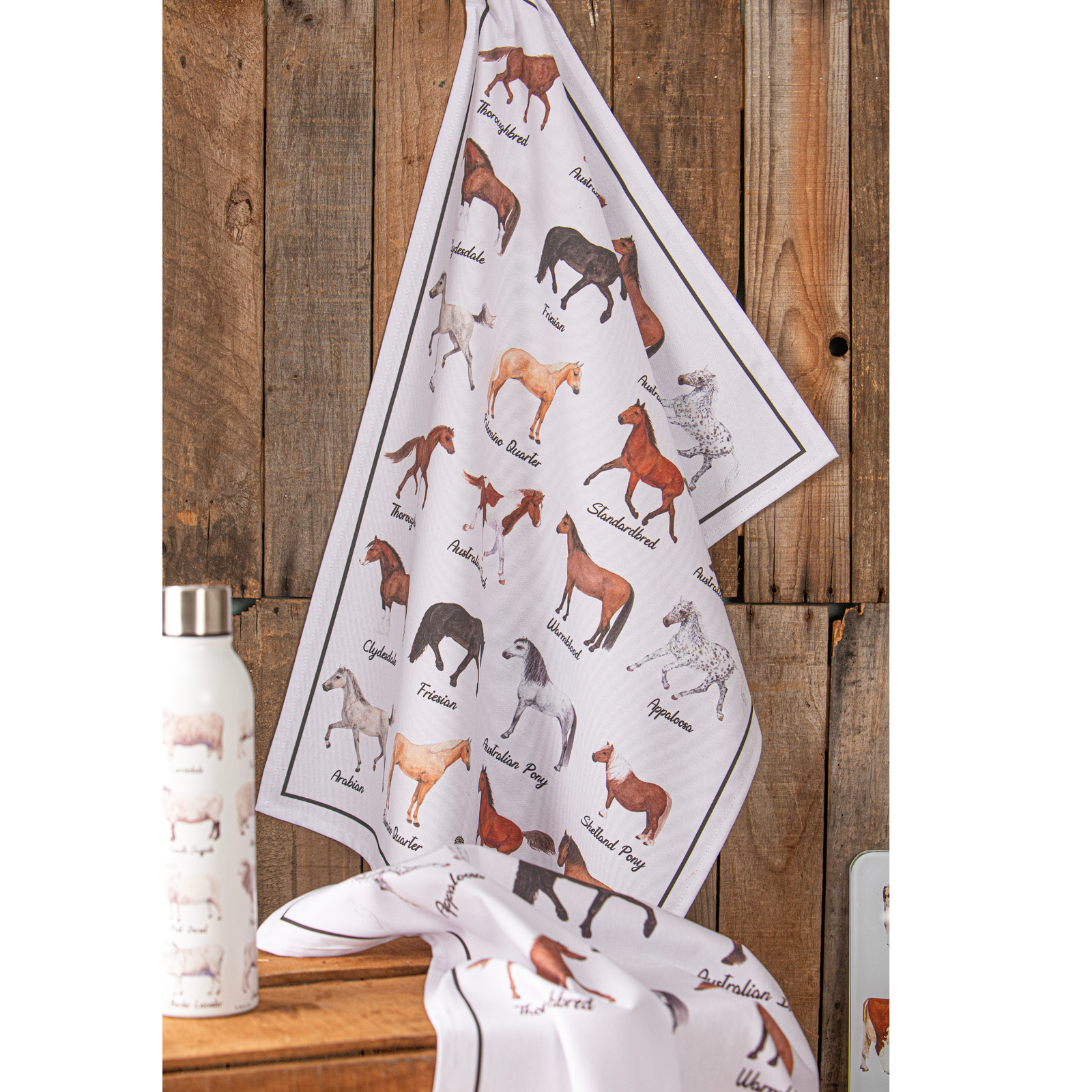 Tea towel with horse illustrations hanging on a wooden surface