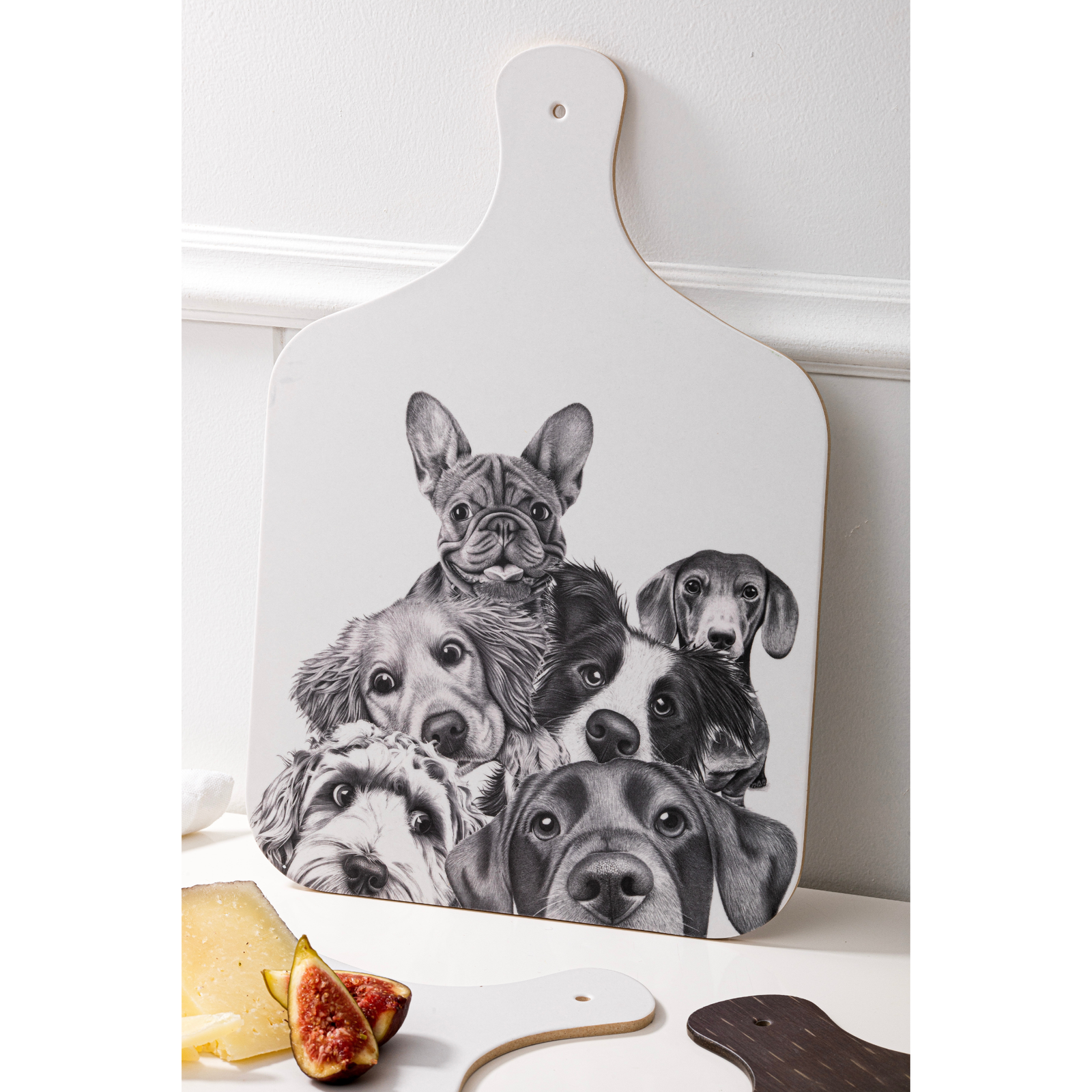 White cutting board with black and white illustrations of dogs on a white surface.