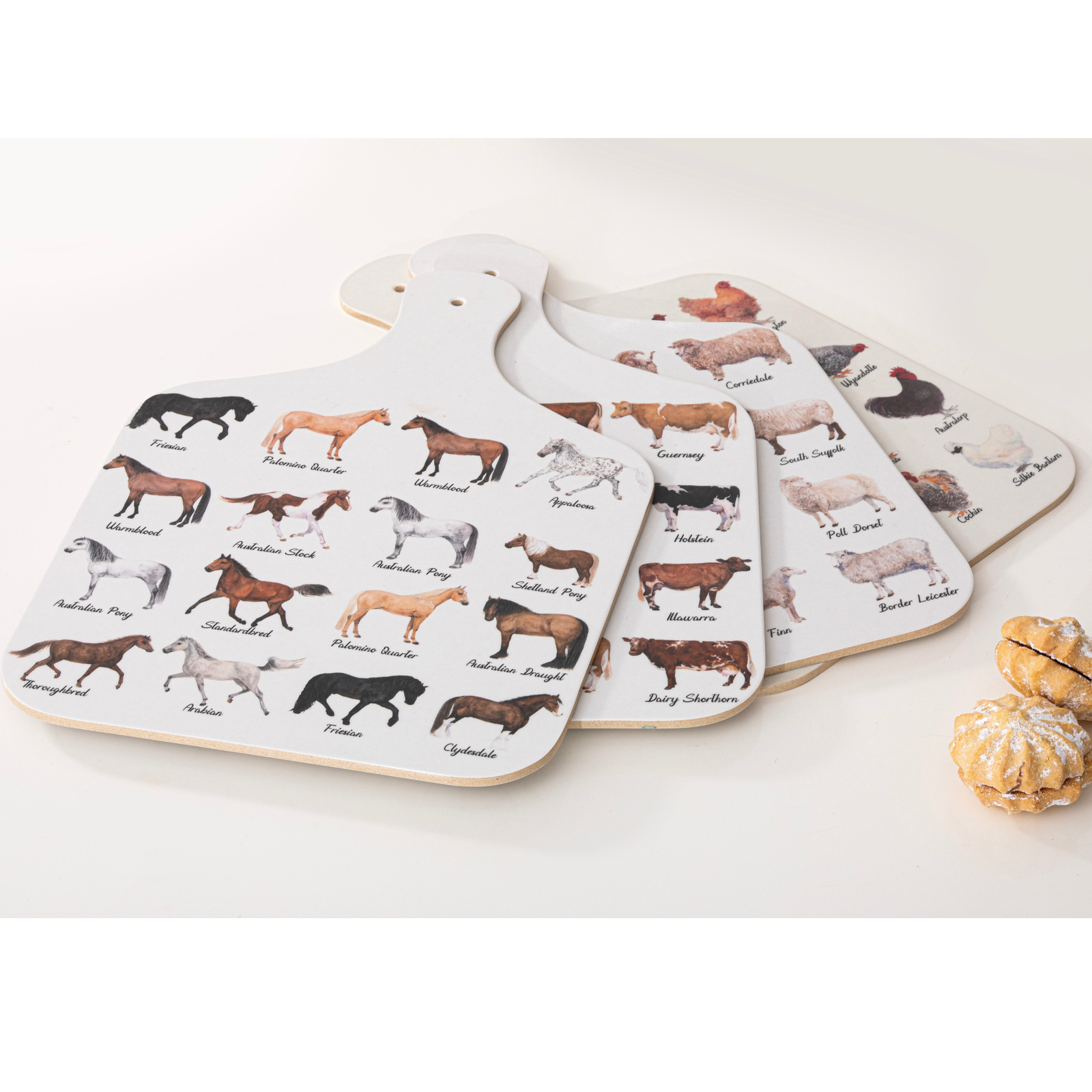 Set of four cutting boards with animal illustrations on a white surface