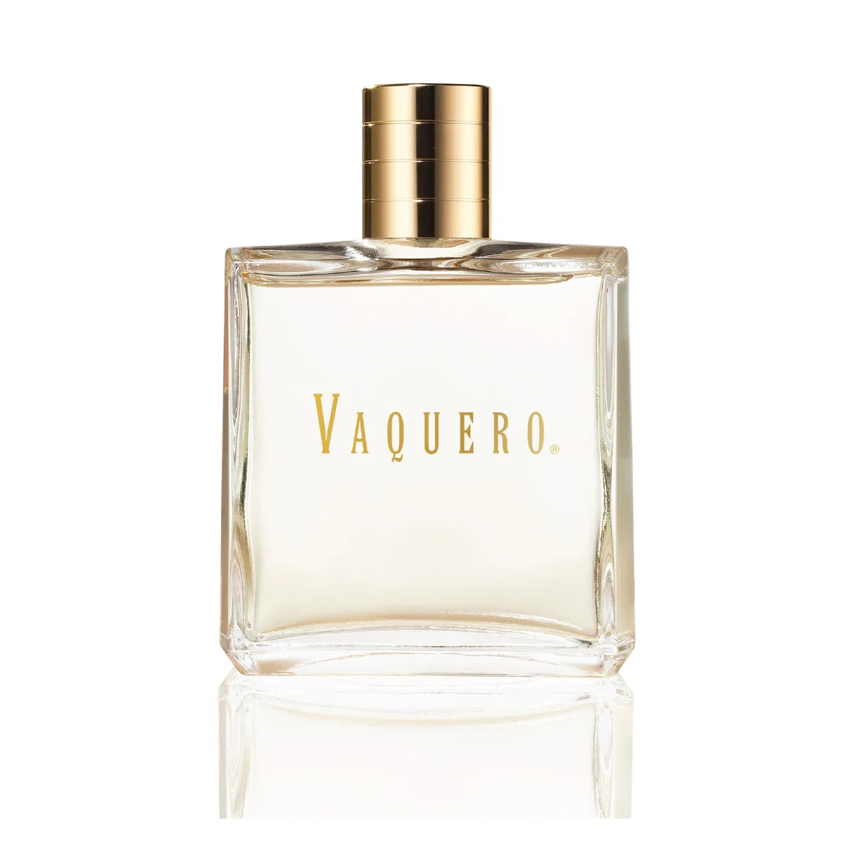 A clear rectangular glass bottle of Vaquero fragrance with a metallic gold cap and gold lettering on the front, shown on a white background with a soft reflection below.