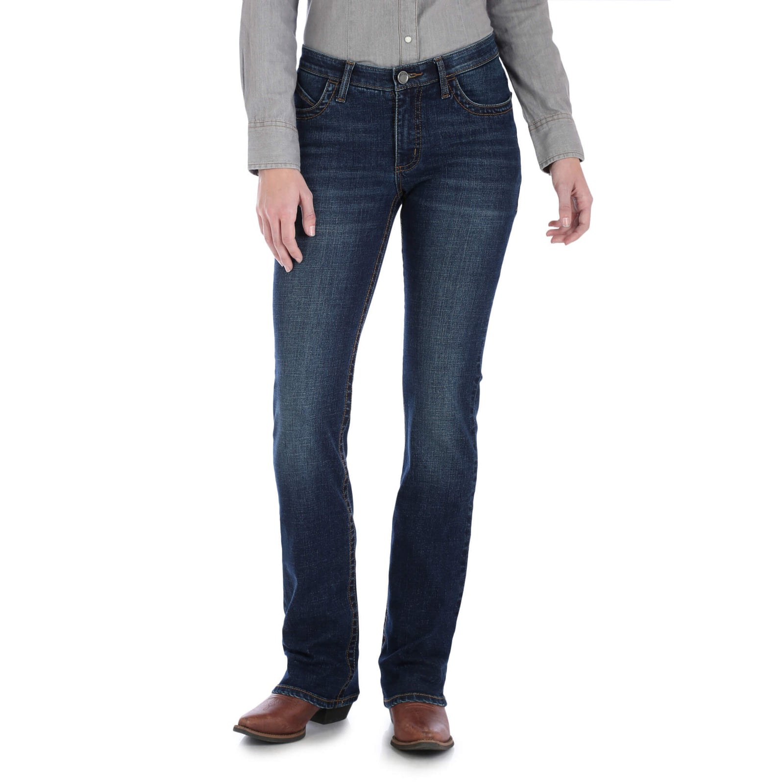 A woman standing, wearing Wrangler Women's Willow Ultimate Riding Jeans with a high-rise waist and slim fit, in a medium wash denim.
