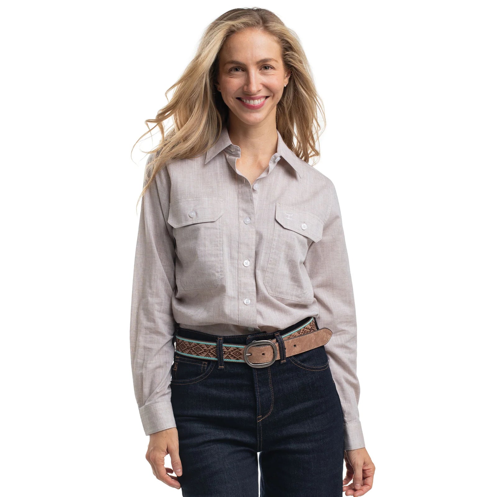 Woman wearing a light gray shirt and dark jeans with a belt on a white background