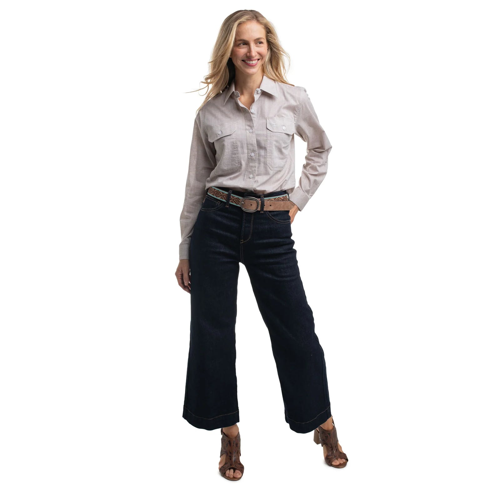 Woman wearing a light-colored shirt and dark jeans on a white background