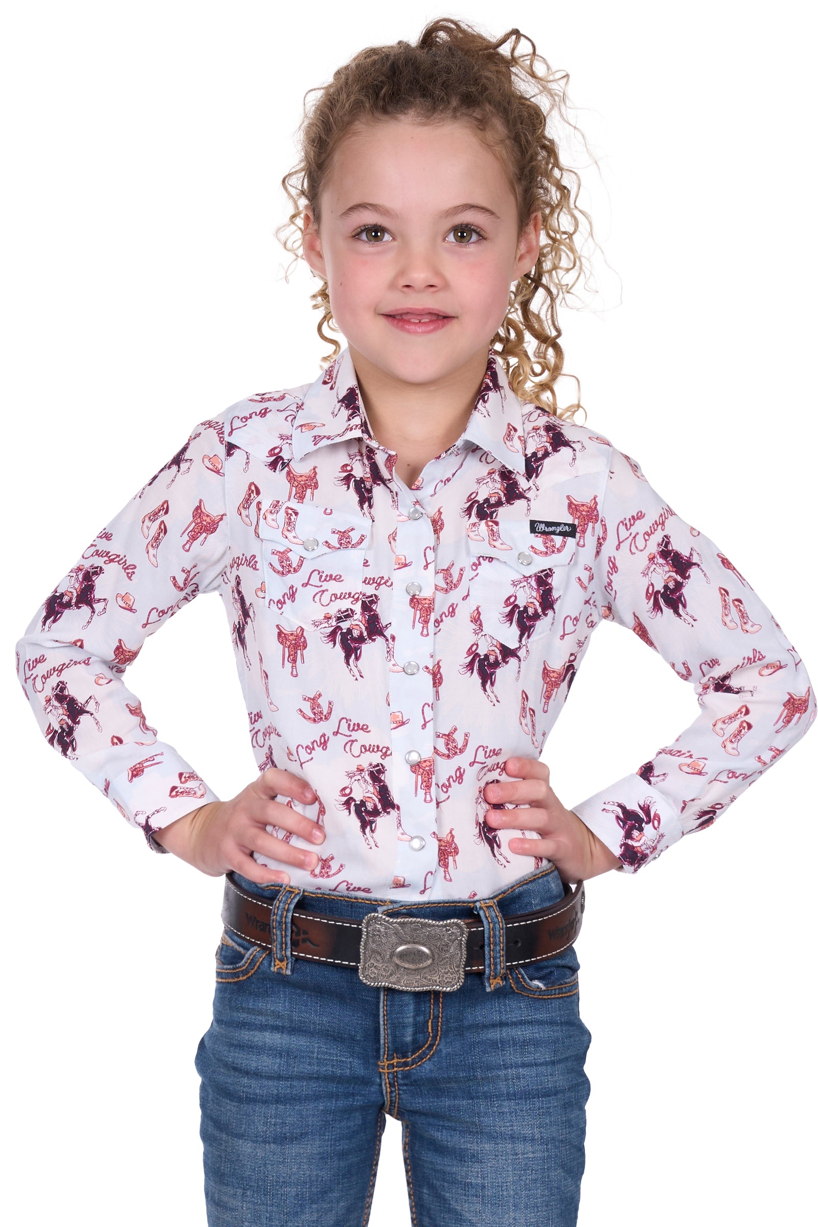Wrangler Girl's Doreen L/S Western Shirt. Young girl wearing a long-sleeve shirt with horse print and jeans on a white background