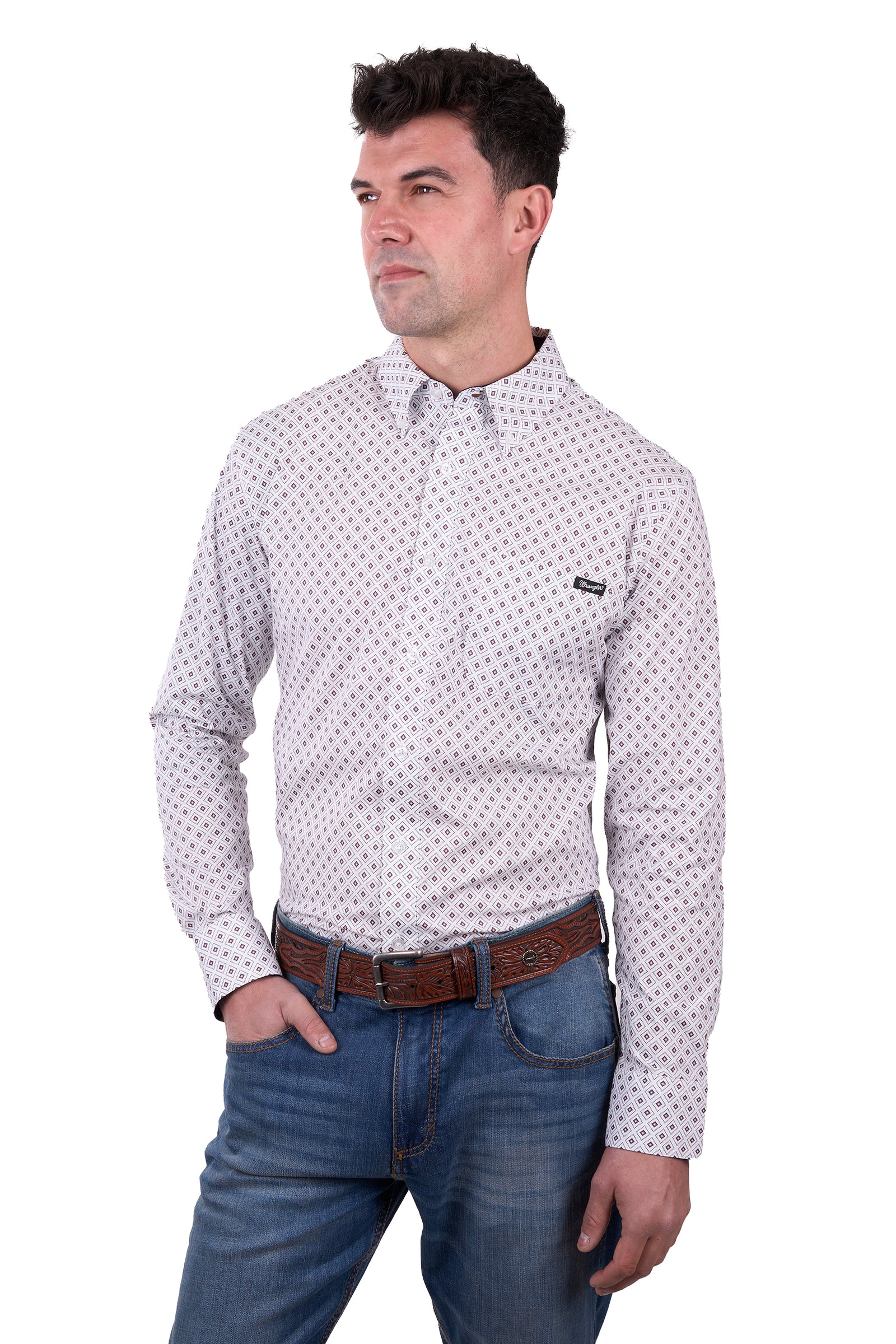A man wearing a long-sleeved, button-down, checkered white and blue Wrangler Men's Knox Western Shirt with a pointed collar, paired with blue jeans and a brown belt.