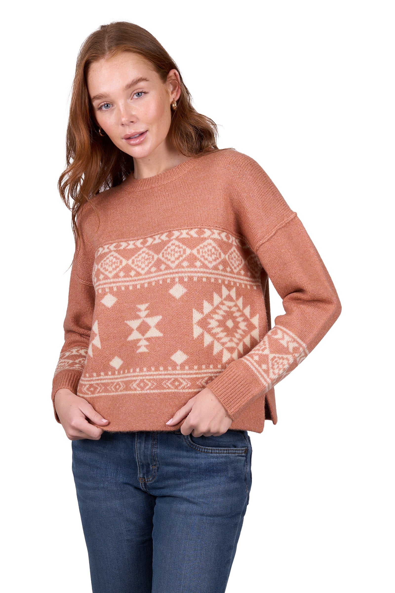 A woman wearing awrangler western peach crew neck jumper with a geometric pattern and rib trim, paired with blue jeans.