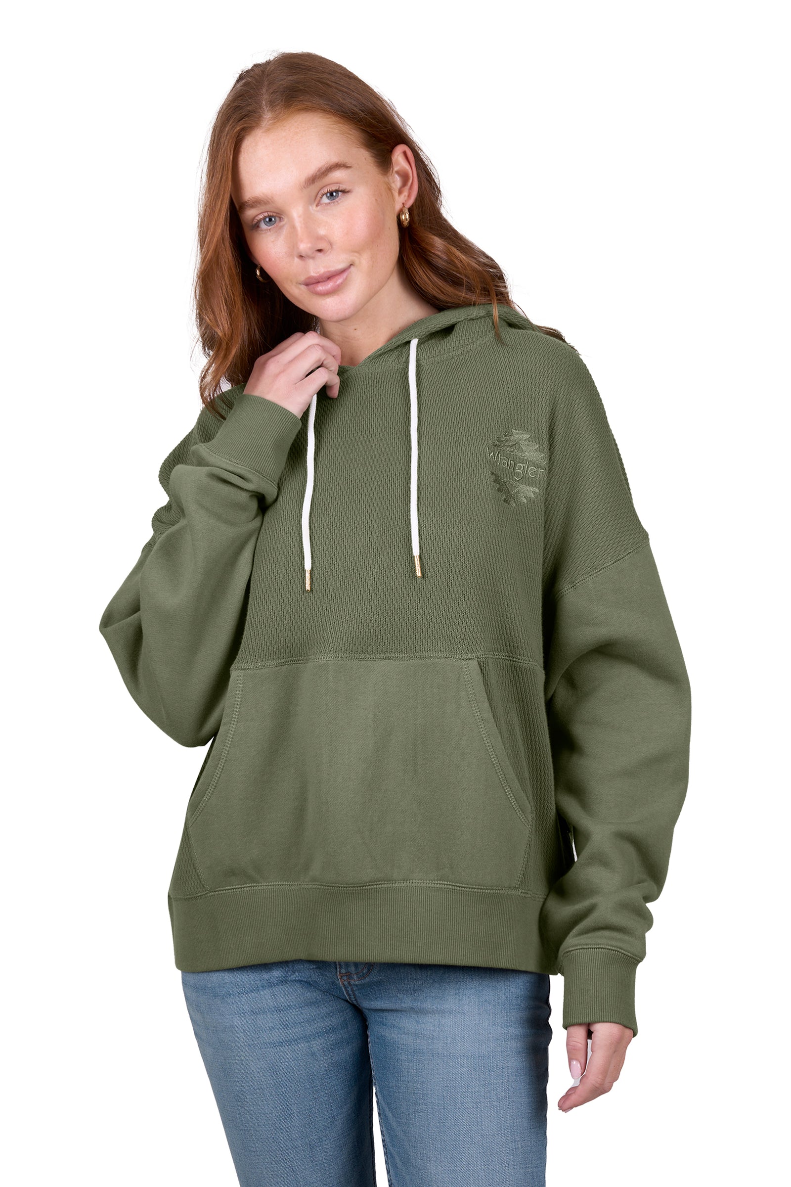 A woman wearing a green Wrangler Women's Lisa Hoodie with a front kangaroo pocket, hood with drawcord, and the Wrangler logo on the chest.