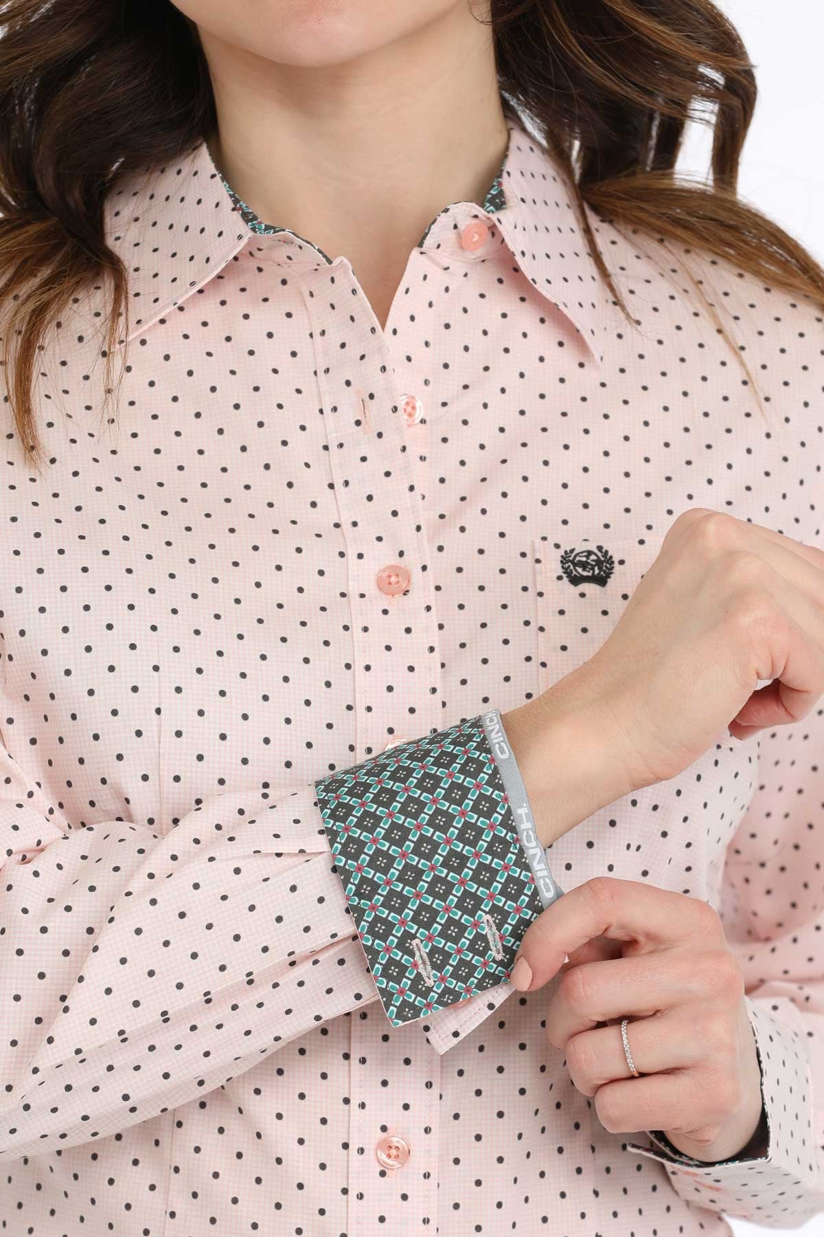Cinch Women's Geometric Print L/S Western Shirt. Close-up of a person wearing a pink polka dot shirt with patterned cuffs.