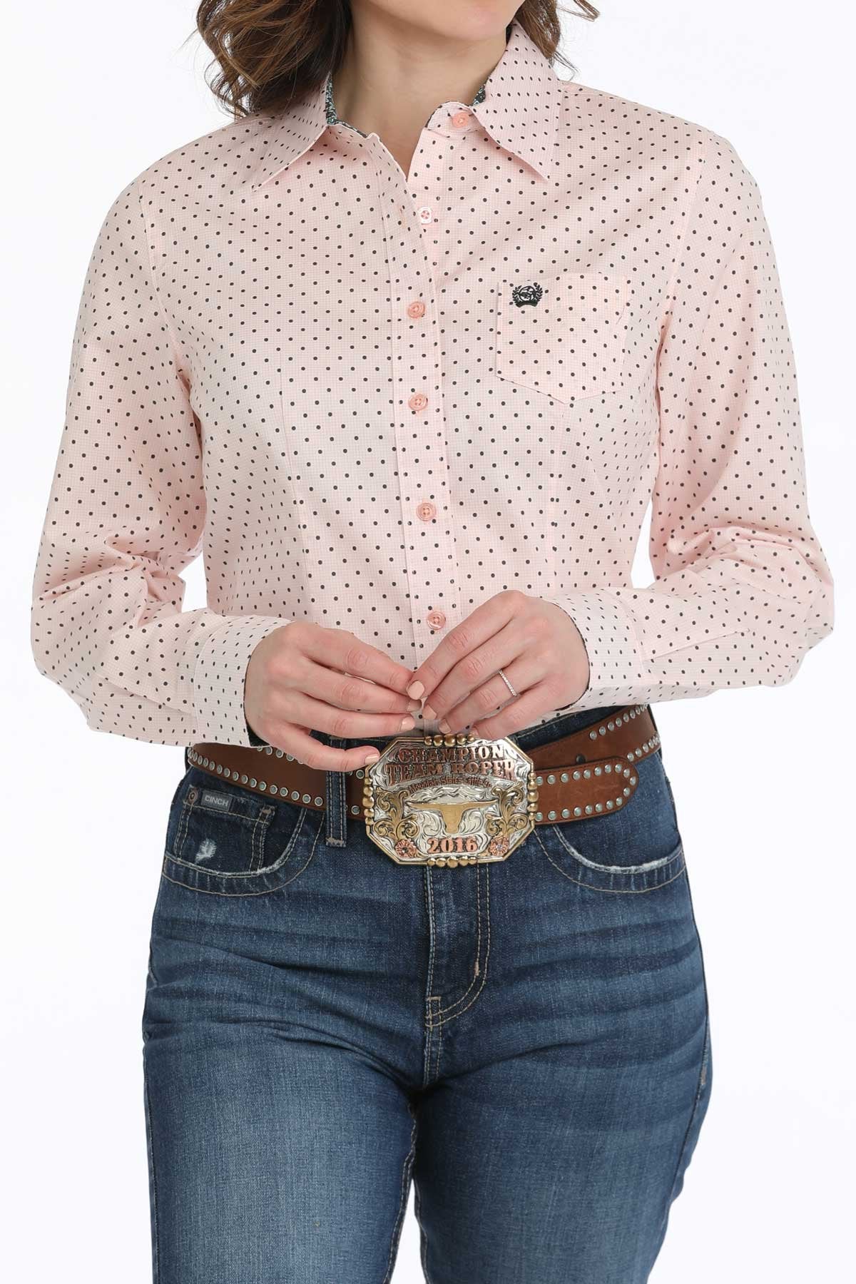 Cinch Women's Geometric Print L/S Western Shirt. Person wearing a pink patterned shirt and blue jeans with a large belt buckle.