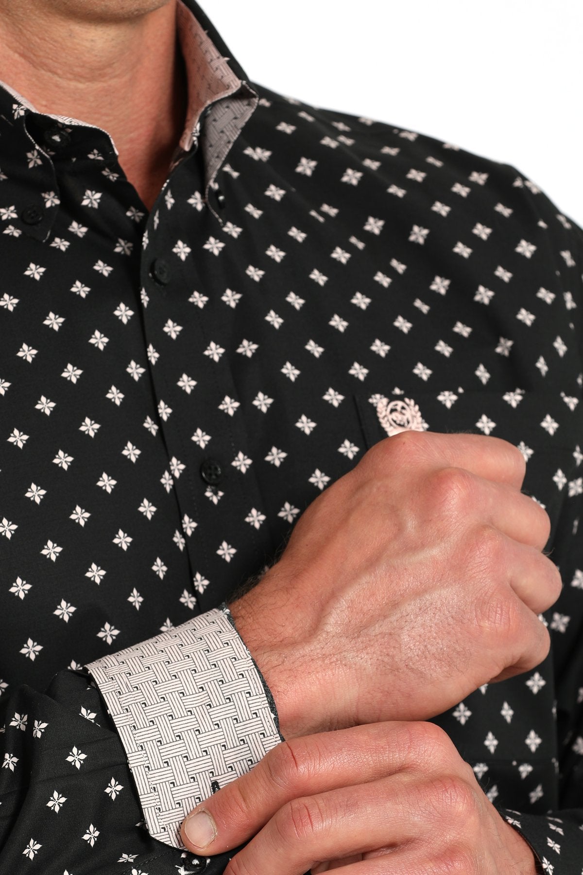 Cinch Men's Geometric Print L/S Western Shirt. Close-up of a person wearing a black patterned shirt with a white pattern on the cuffs.