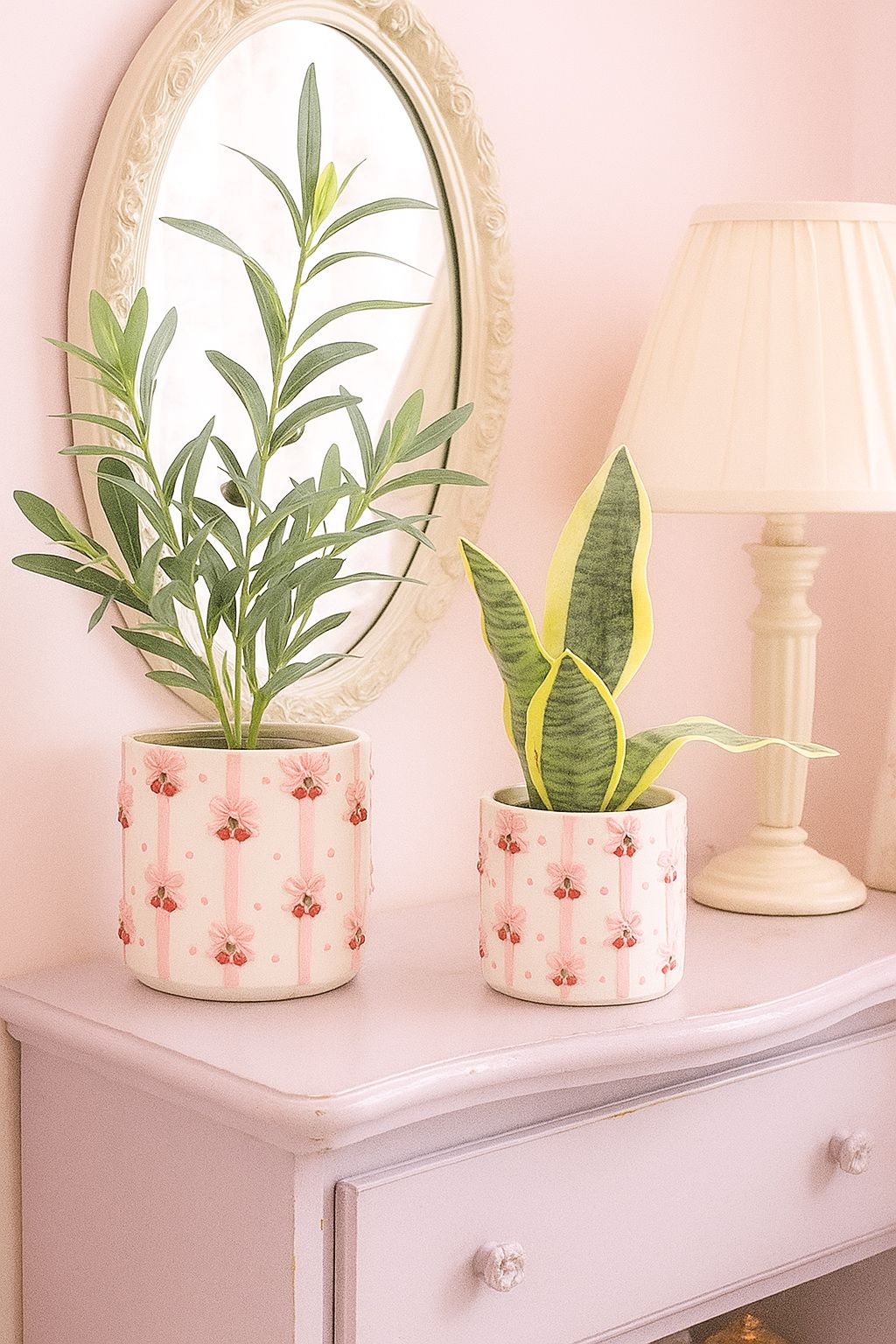 Urban Products 13cm Cherry Bow Planter. Two potted plants on a dresser with a mirror and lamp in the background.