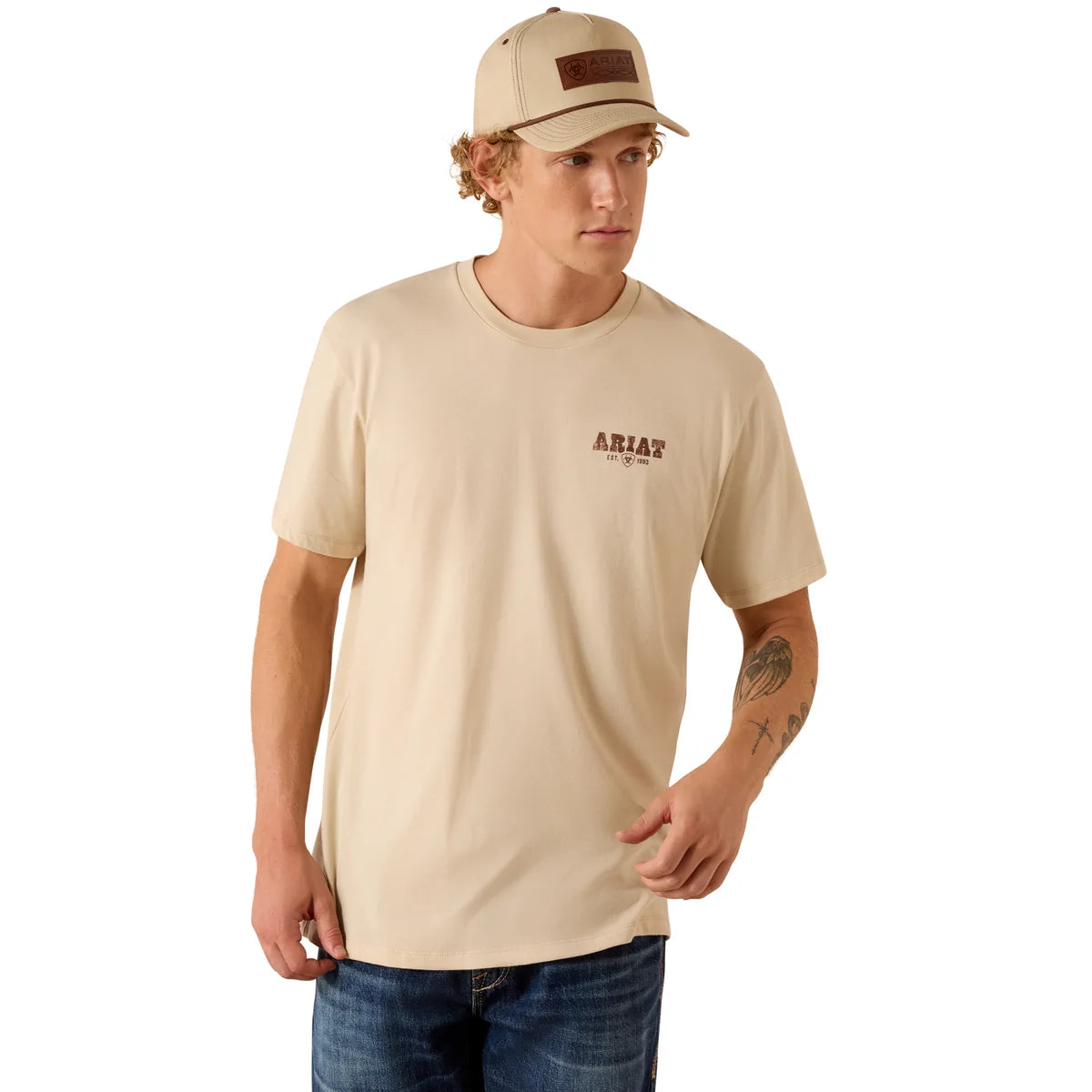 Man wearing a beige t-shirt with a logo and a cap on a white background