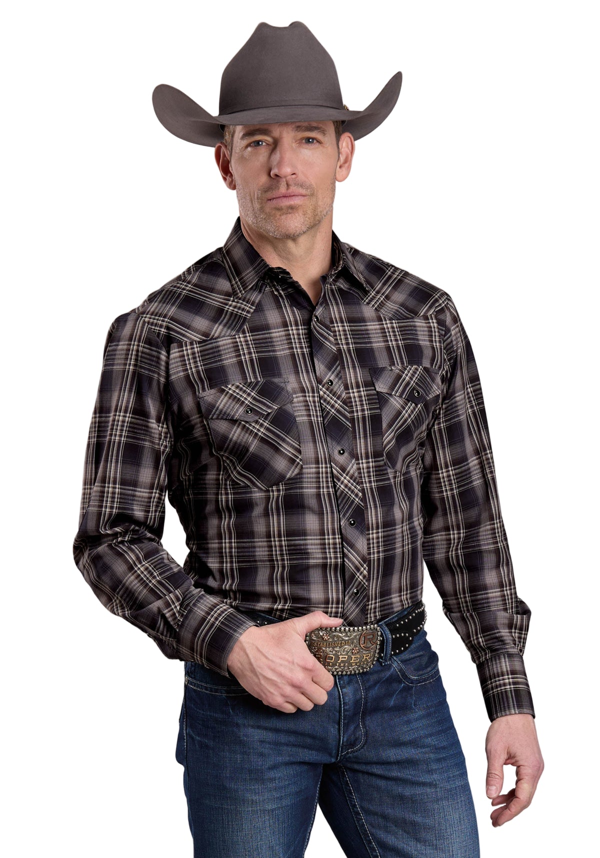 Roper Men's Karman Classic L/S Western Shirt. Man wearing a plaid shirt, jeans, and a cowboy hat on a gray background