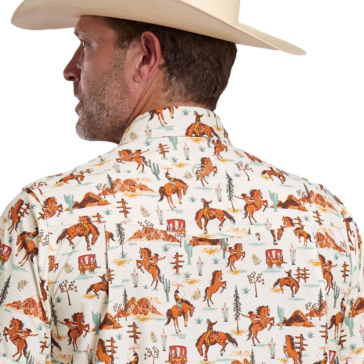 Man wearing a patterned shirt with cowboy-themed design on a white background