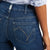 Ariat Women's Abby Perfect Rise Straight Leg Jean. Close-up of blue jeans with a brand label on a white background