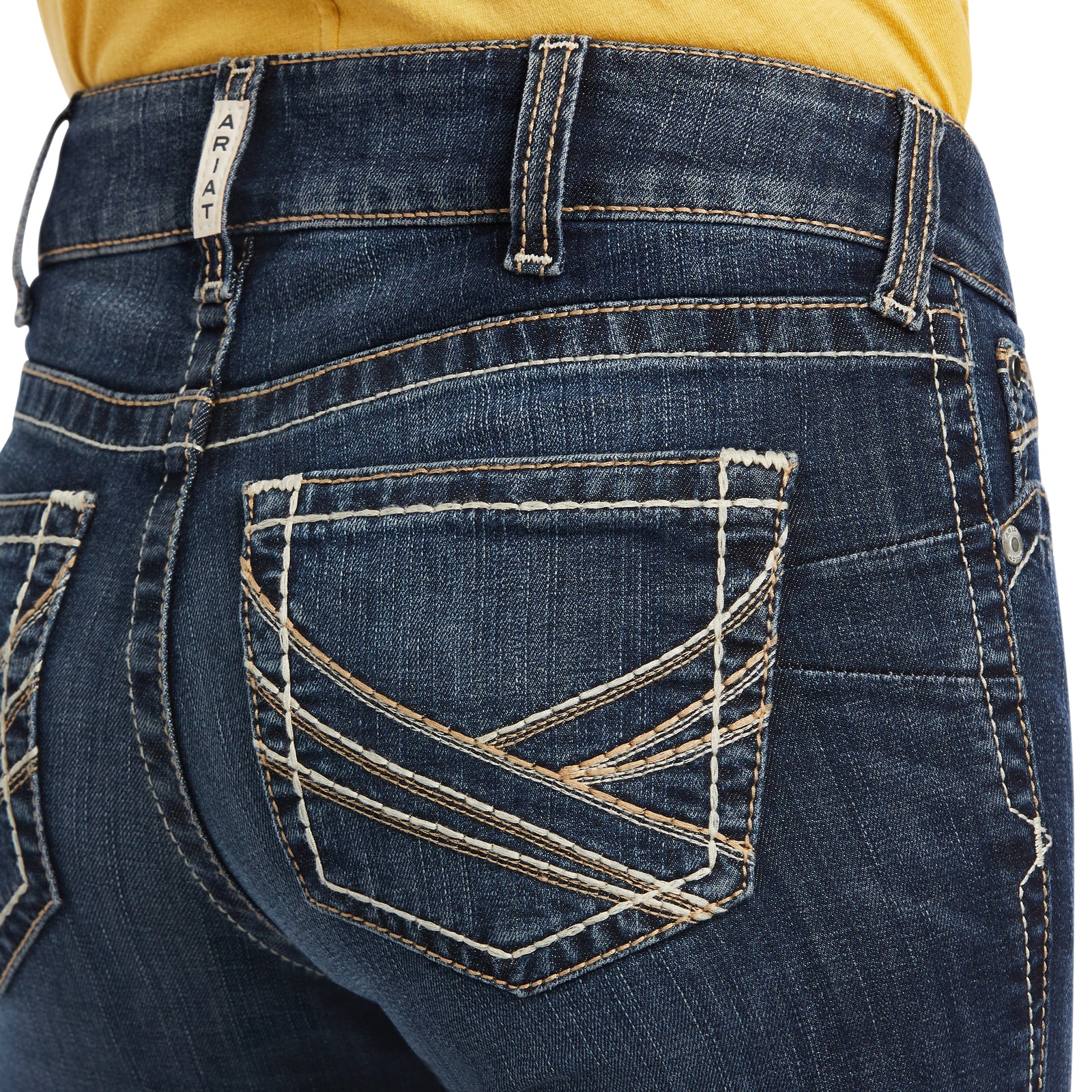 Ariat Women's Lexie Perfect Rise Boot Cut Jean. Close-up of blue jeans with a yellow shirt partially visible
