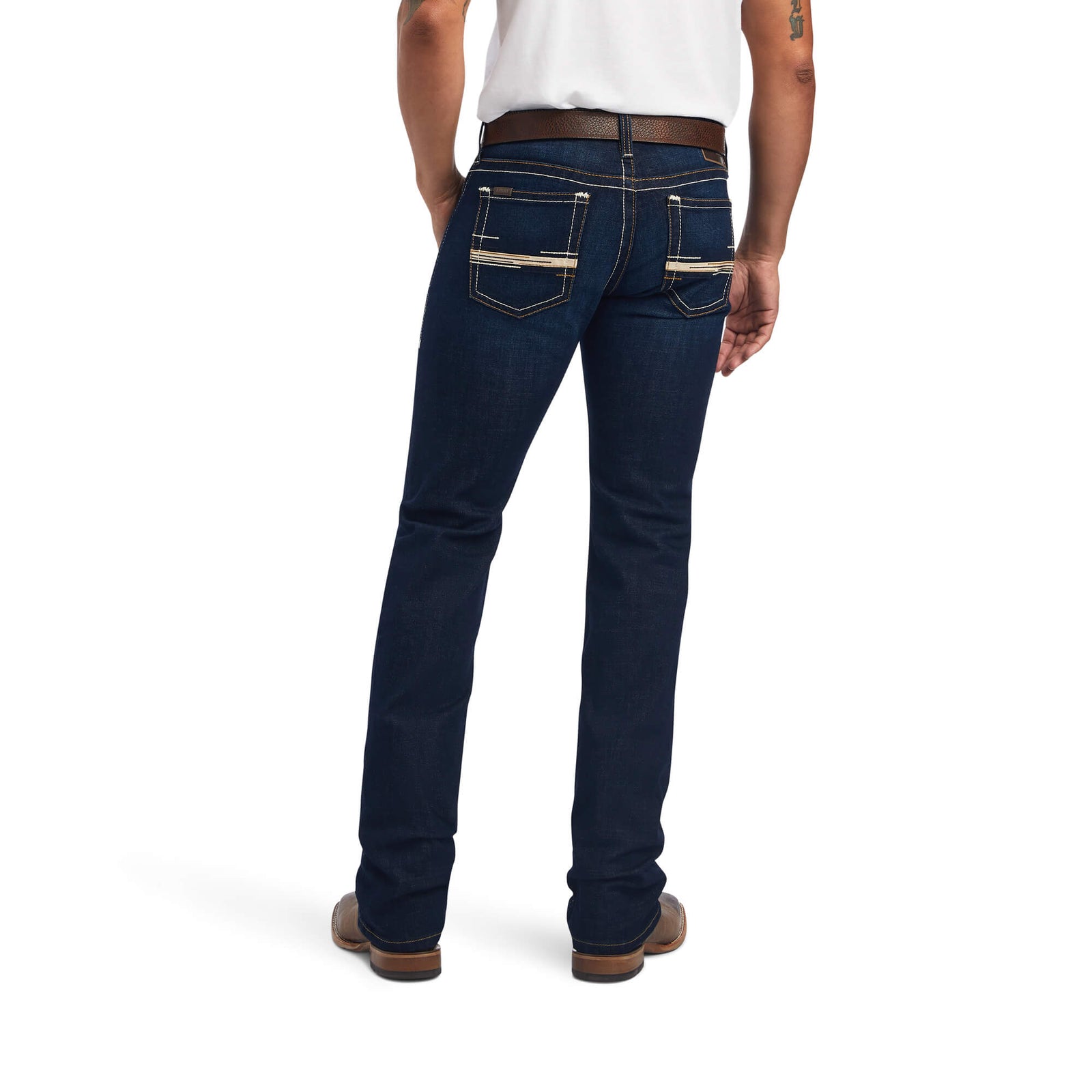A man wearing Ariat Men's M7 Ranger Straight Leg Jean with hands in pockets, standing against a white background.