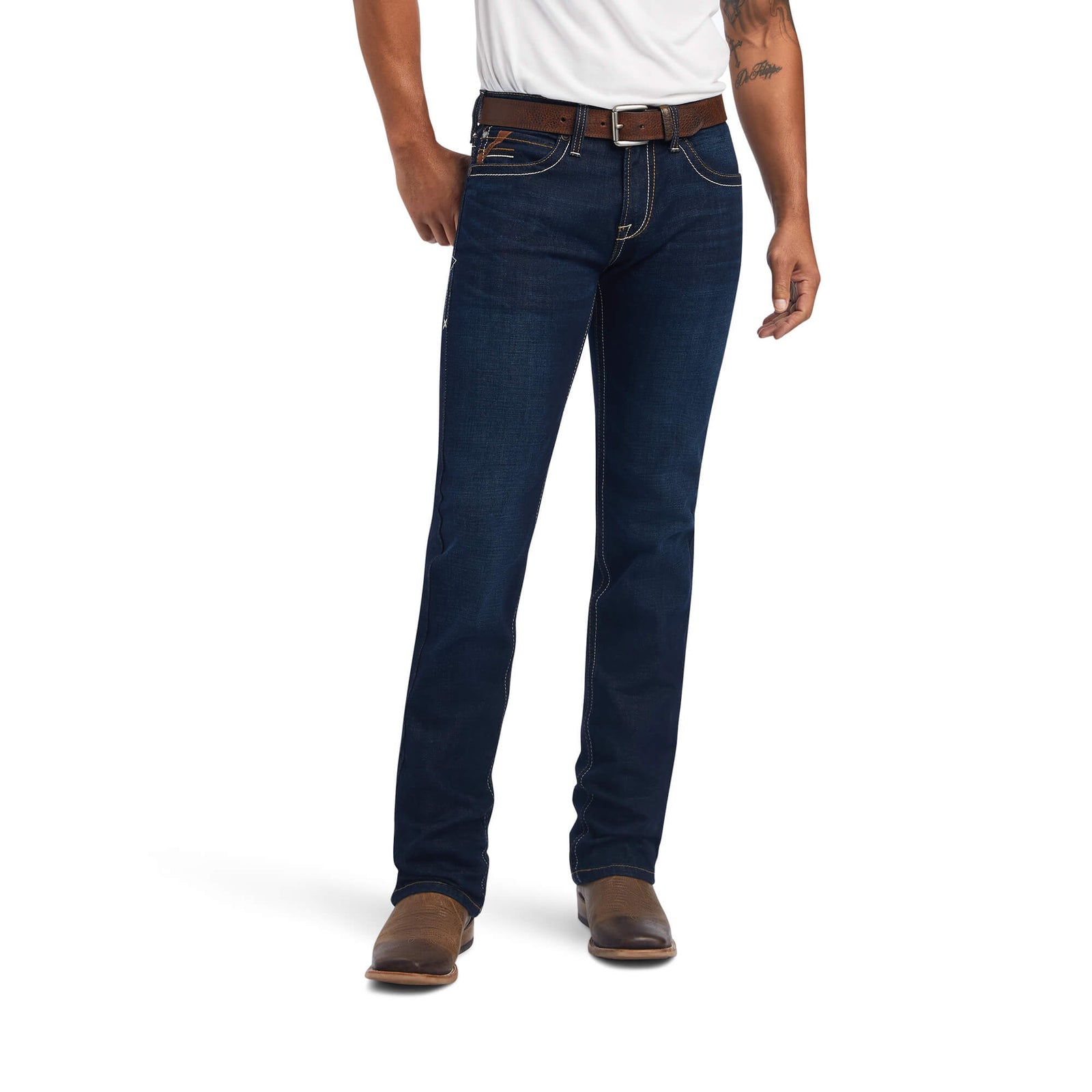 A man wearing Ariat Men's M7 Ranger Straight Leg Jean with hands in pockets, standing against a white background.