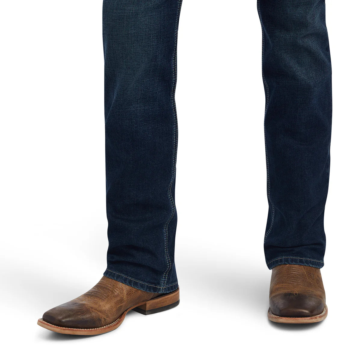 Dark blue jeans worn with brown leather boots on a white background