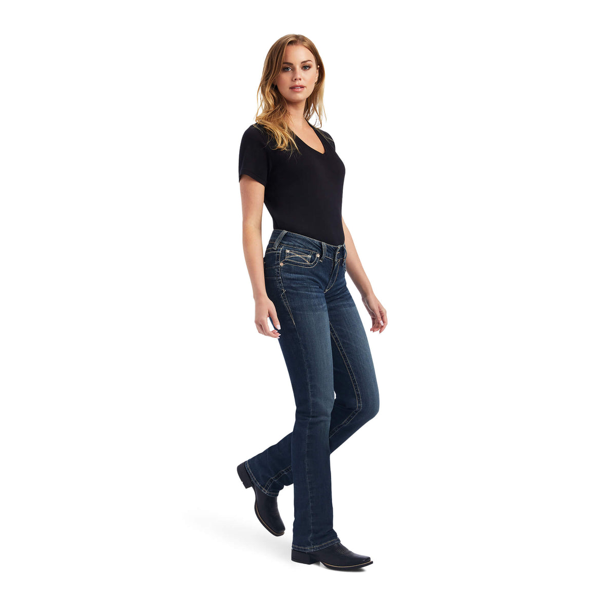 Ariat Women's Freesia Straight Leg Jean. Woman wearing dark blue jeans and a black top on a white background