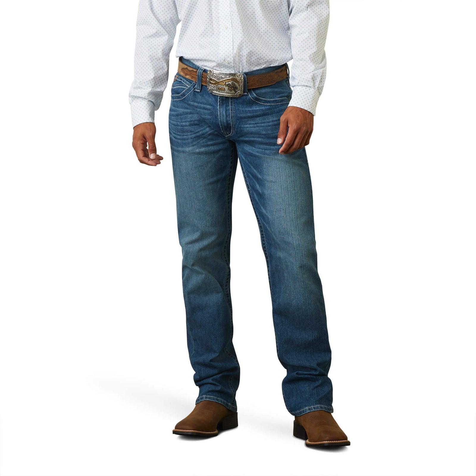 A man standing straight, wearing a white shirt and Ariat Men's M5 Devon Straight Leg Jeans with brown boots and a brown belt.