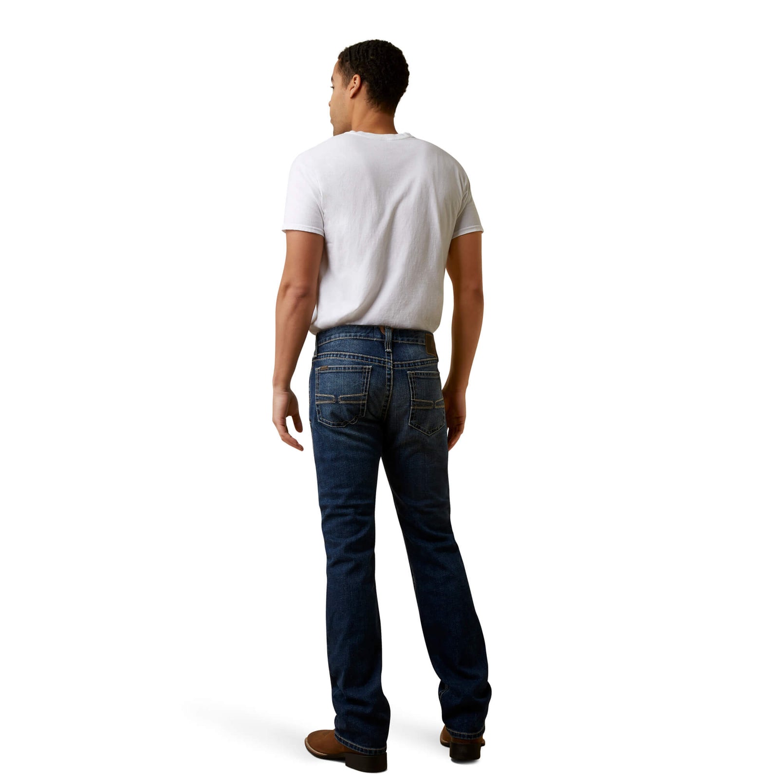 A man wearing Ariat Men's Graysill M7 Straight Leg Jean with a white shirt and brown boots.