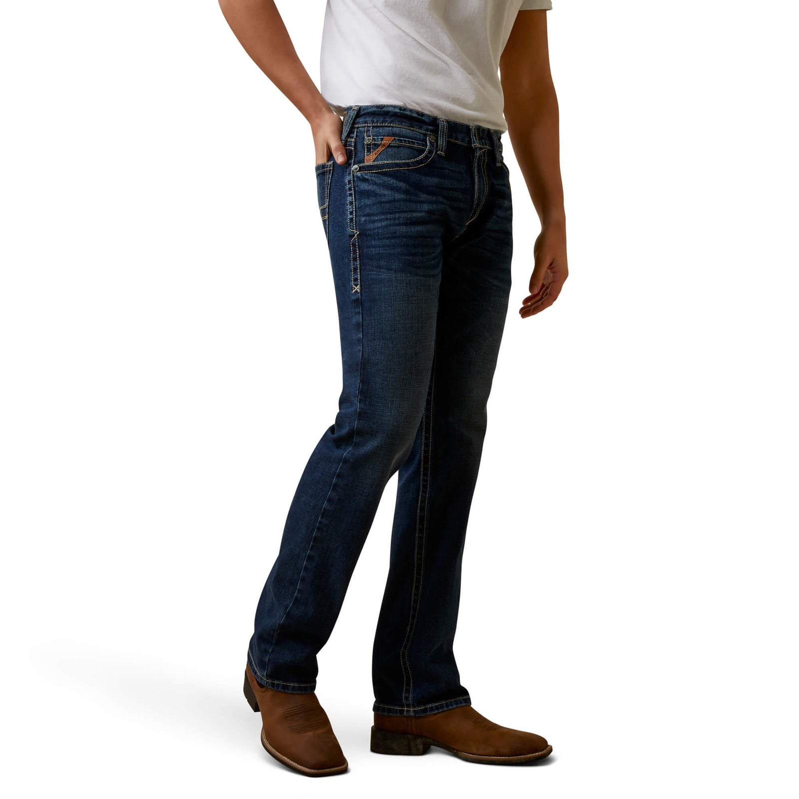 A man wearing Ariat Men's Graysill M7 Straight Leg Jean with a white shirt and brown boots.