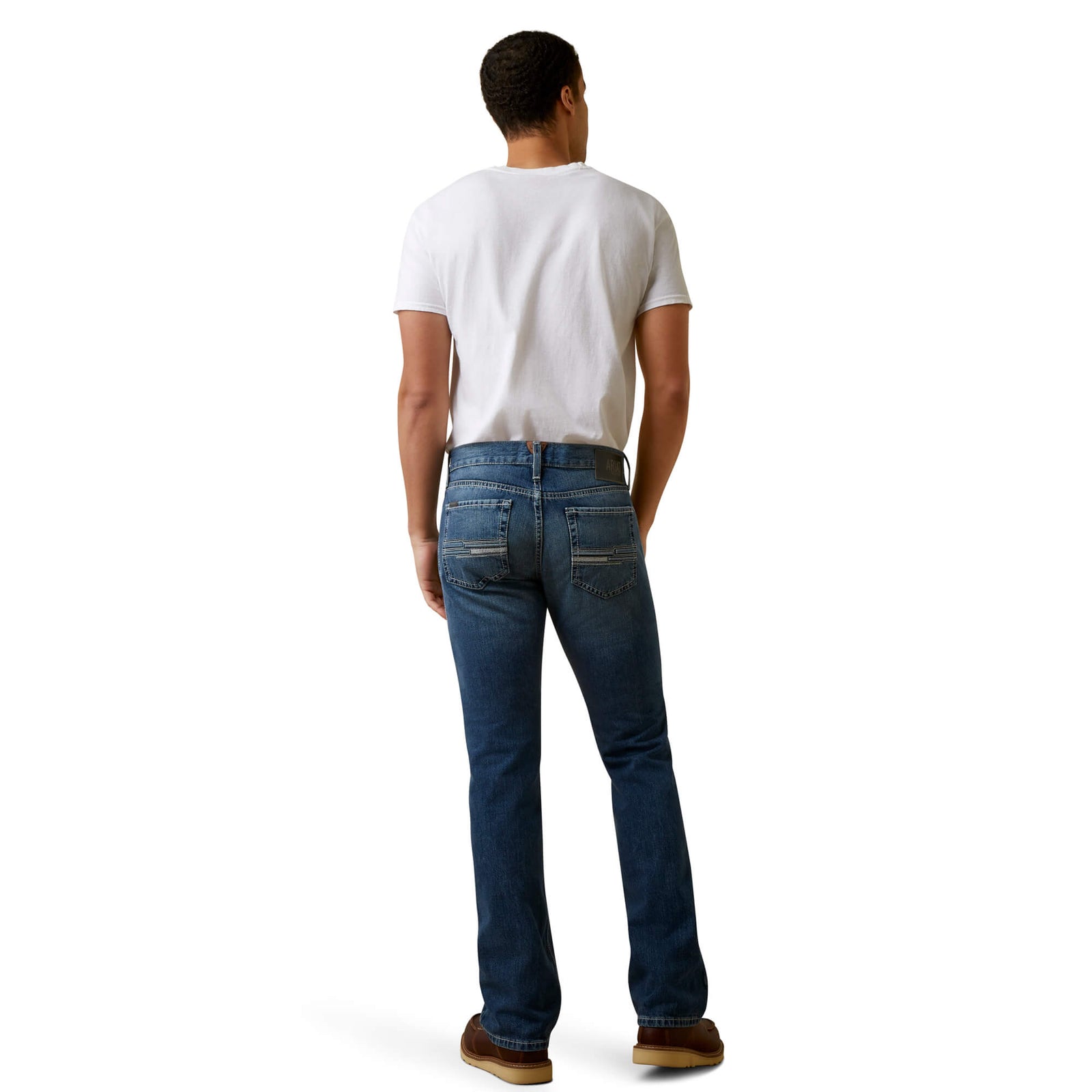 A man standing straight, wearing Ariat Men's Griffen M7 Straight Leg Jean and a white t-shirt, with no visible footwear.