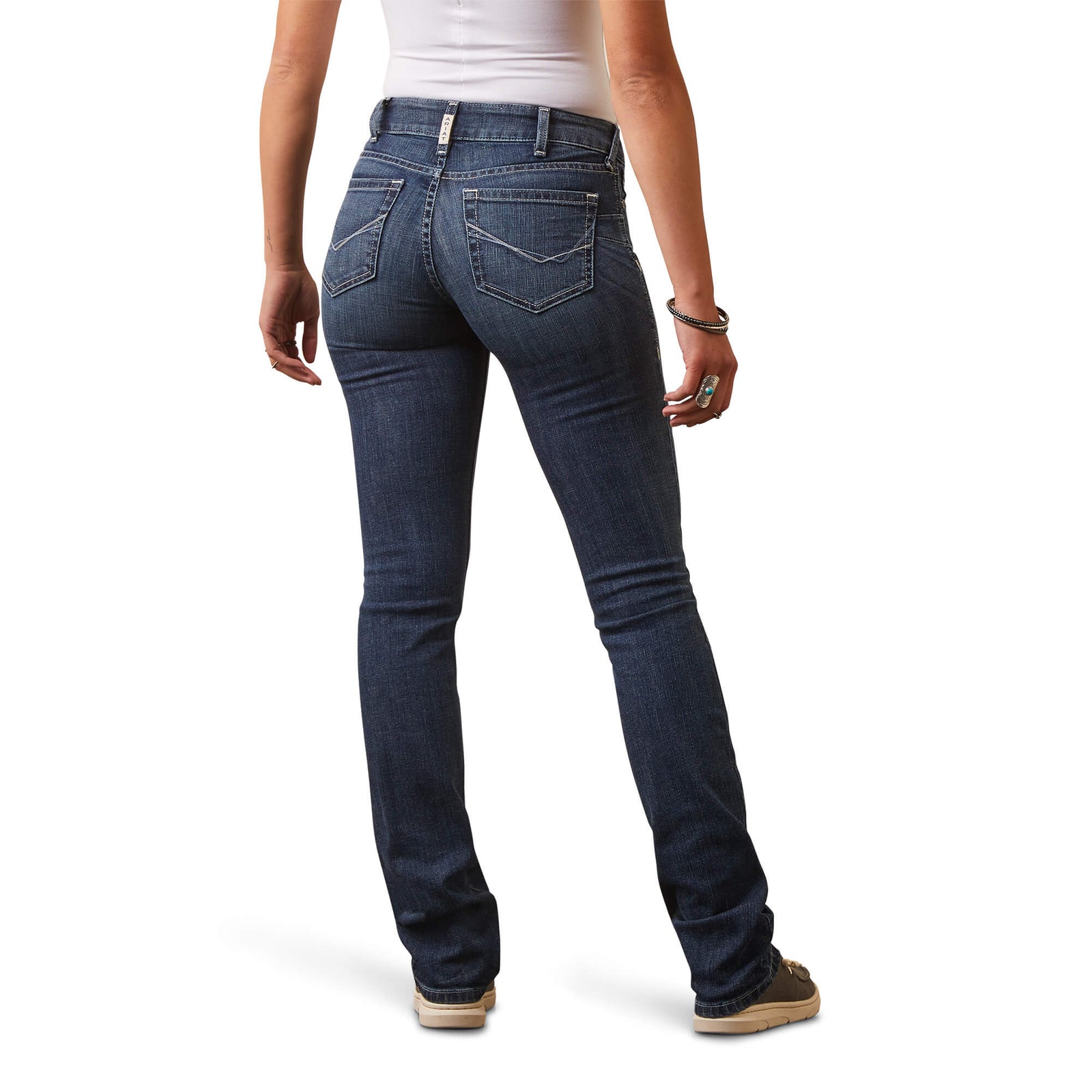 A woman standing, wearing Ariat Women's Madyson Perfect Rise Jeans with a straight-leg cut and a mid-rise waist.