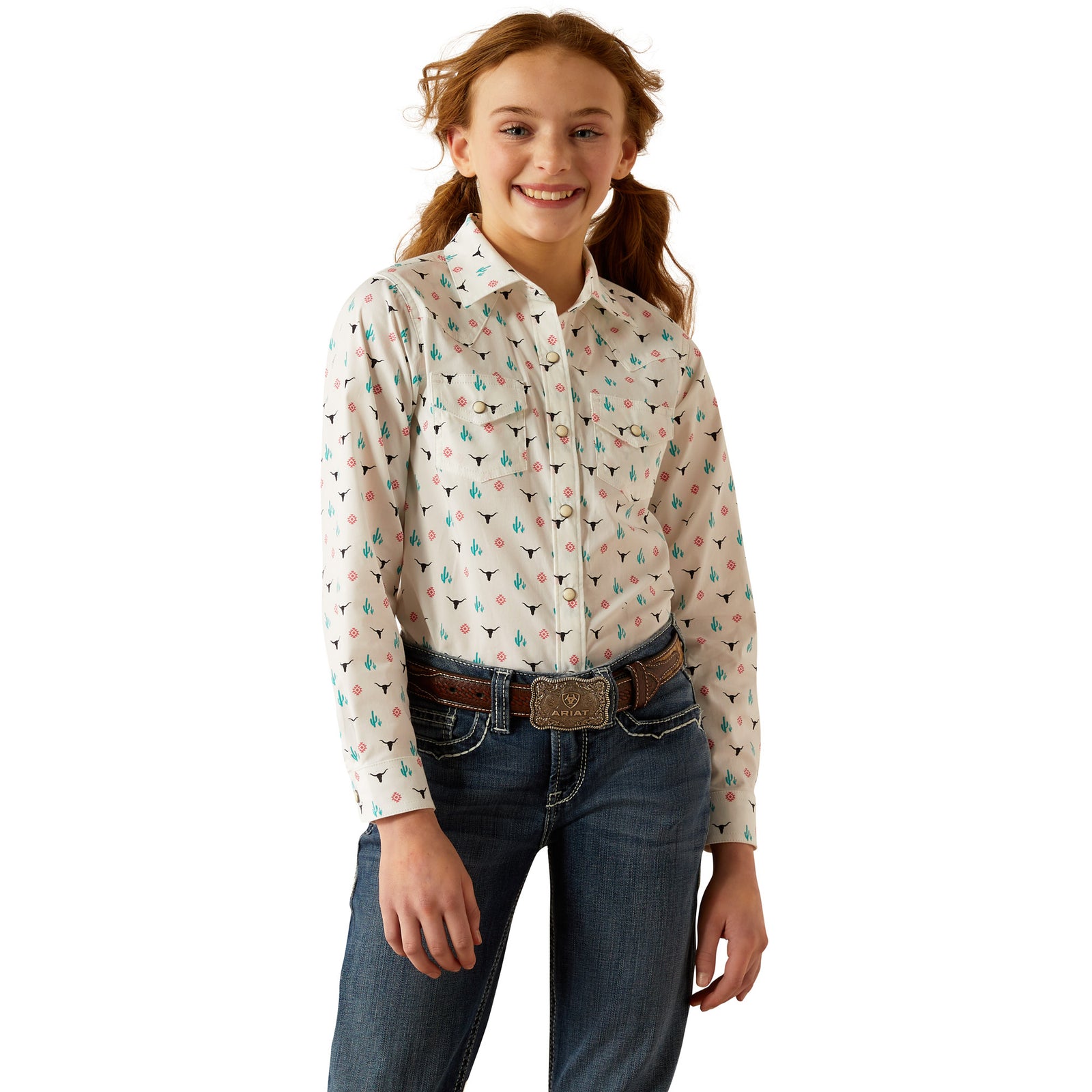 Ariat Girl's Steer Garden L/S Western Shirt. A young girl wearing a long-sleeved Western shirt with a colorful plaid pattern and button-down front, paired with blue jeans.