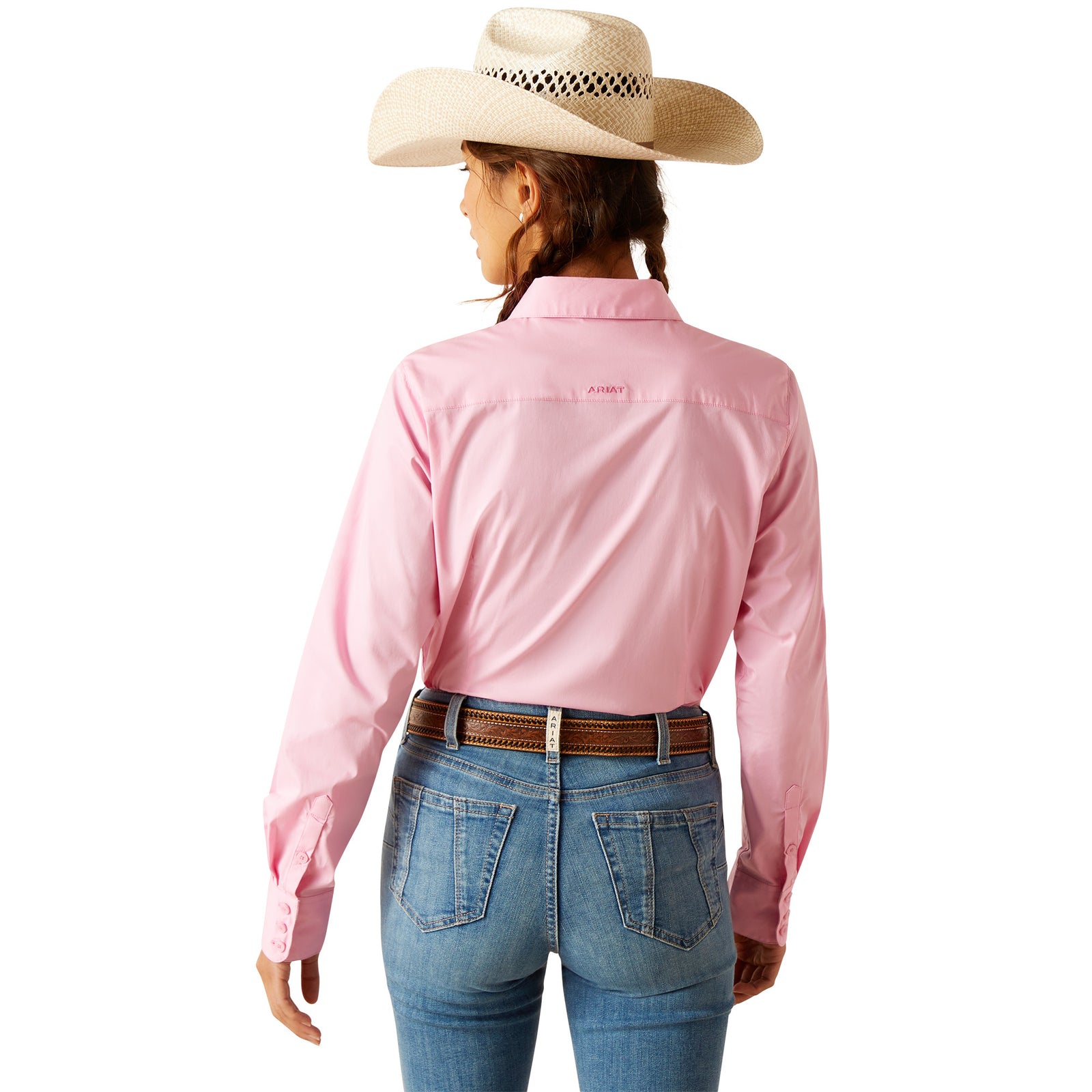 Ariat Women's Kirby Stretch L/S Western Shirt. A woman wearing a pink long-sleeve western shirt with a white cowboy hat, blue jeans, and brown boots.