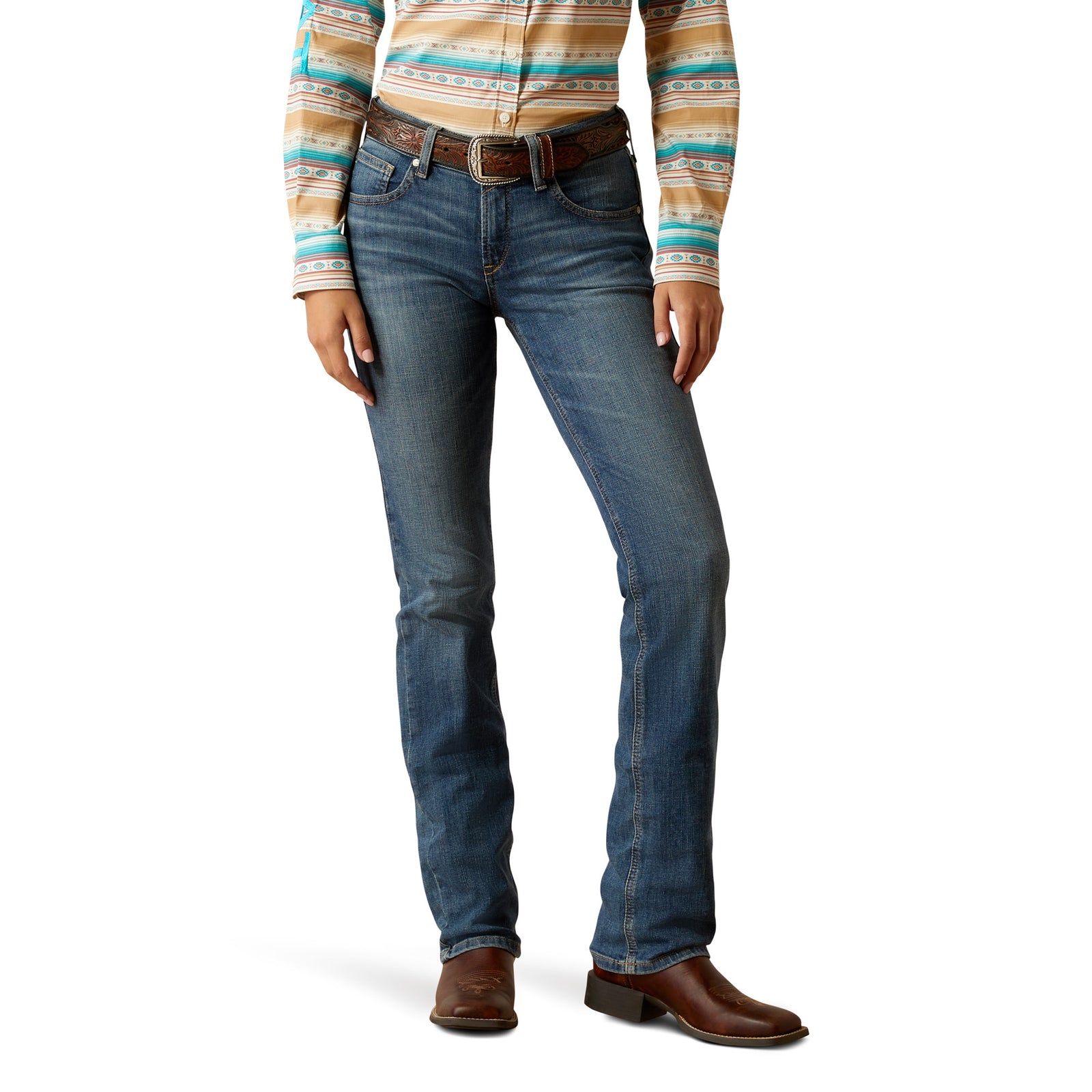 A woman wearing Ariat Women's Abigail Perfect Rise Jean with a relaxed fit, straight leg, and a tapered fit, in a medium wash denim with a unique back-pocket design.