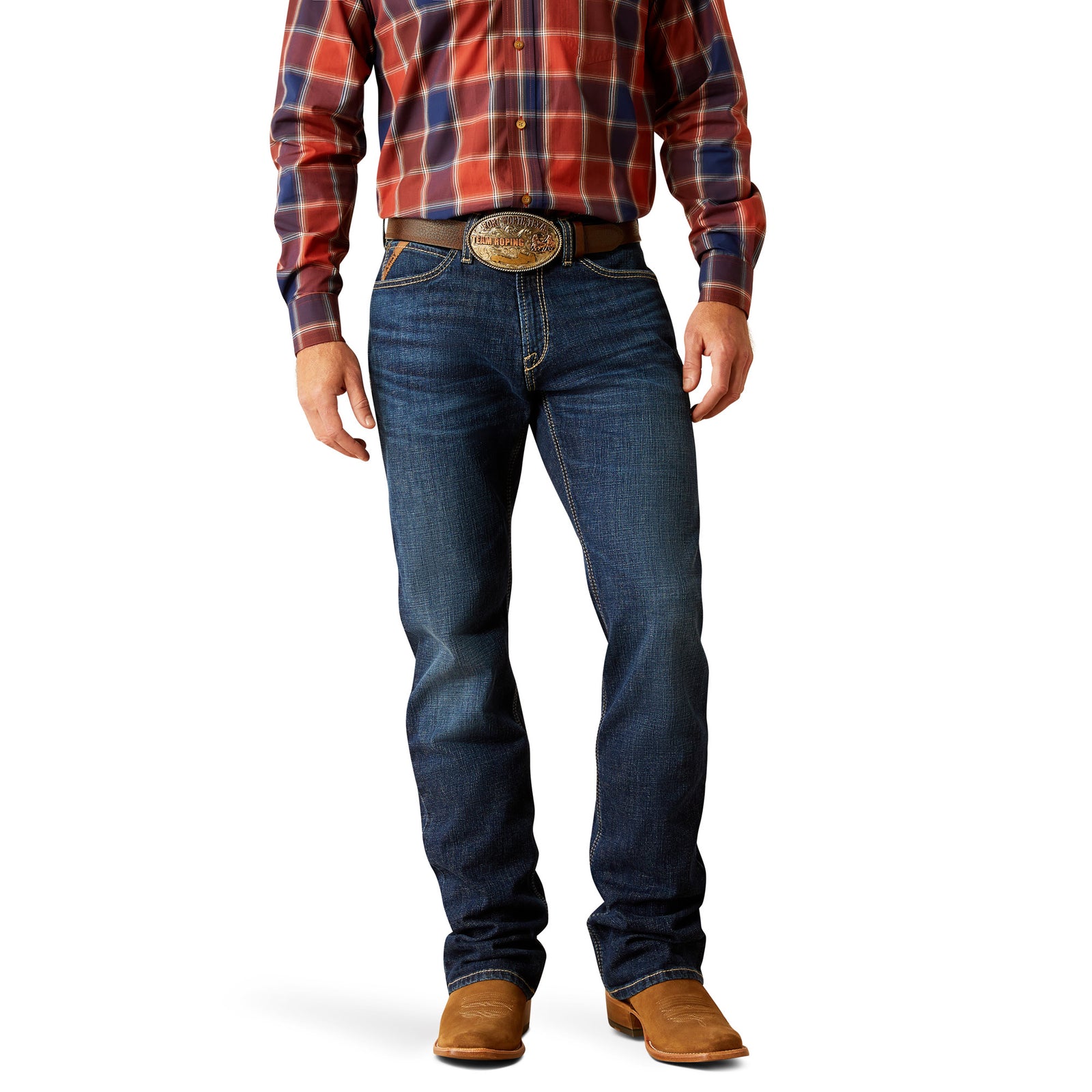 Ariat Men's M4 Challenger Relaxed Fit Jeans. A man standing straight, wearing a plaid shirt, a belt, and brown boots, with Ariat Men's M4 Challenger Relaxed Fit Jeans visible.