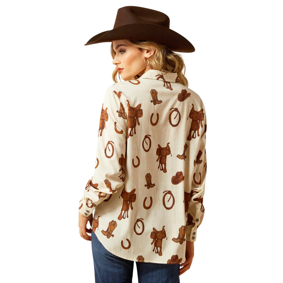 Person wearing a cream-colored shirt with brown cowboy pattern and a brown hat on a white background