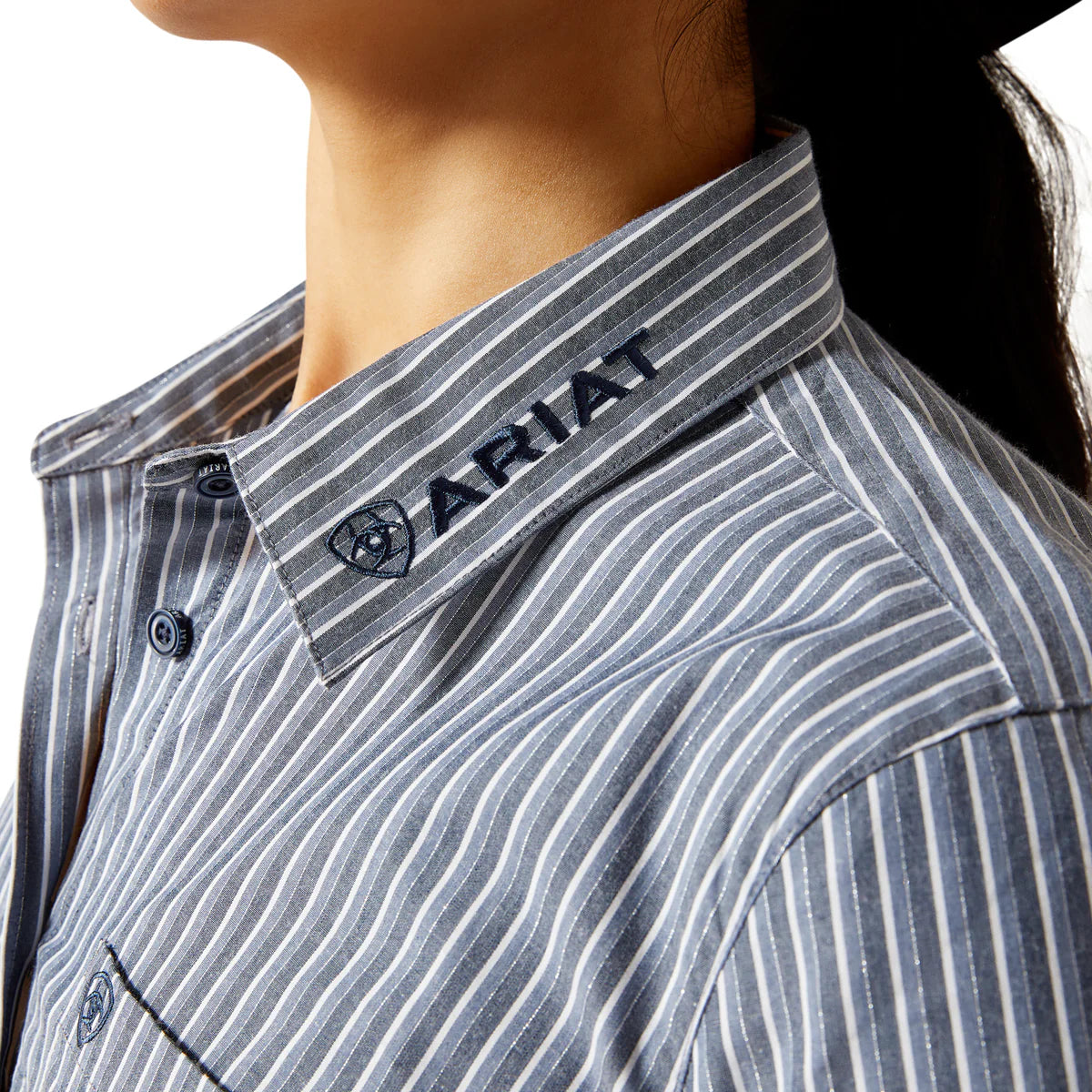 Close-up of a person wearing a striped shirt with Ariat branding on the collar.