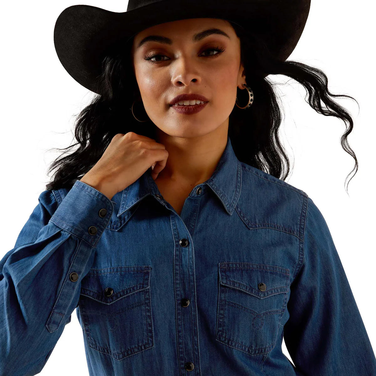 Woman wearing a blue denim shirt and black cowboy hat on a white background