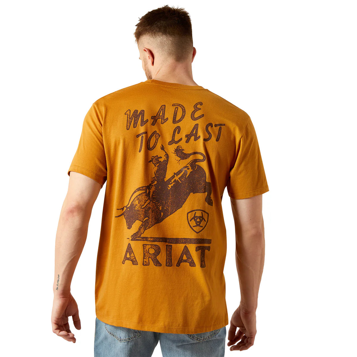 Man wearing a mustard yellow Ariat t-shirt with branding on the back.