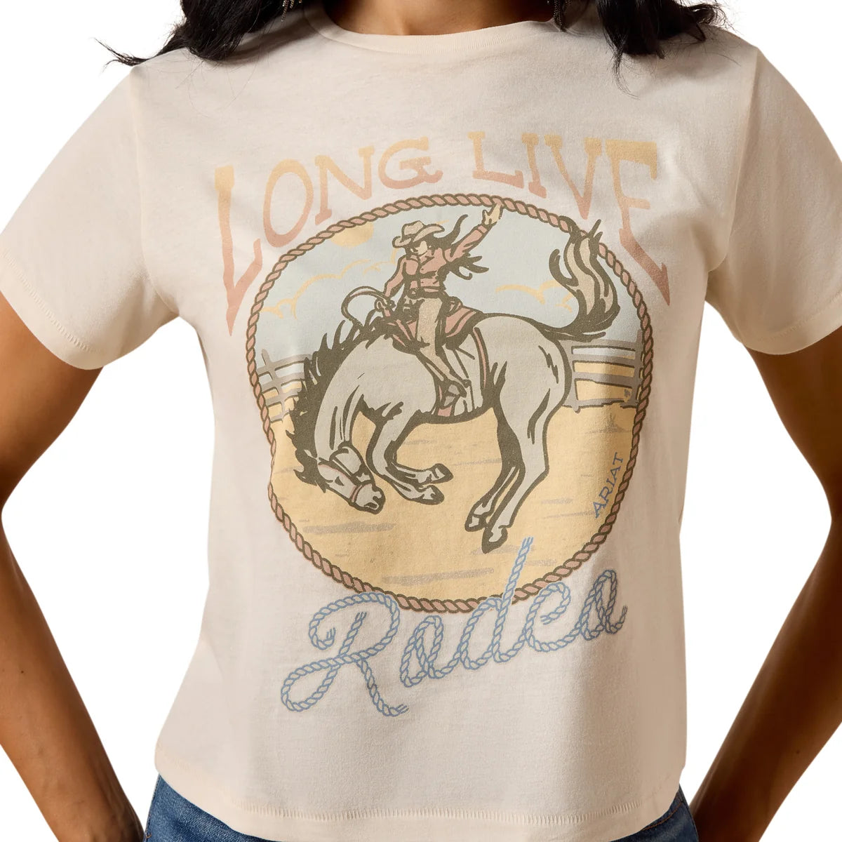 Woman wearing a beige t-shirt with a graphic design and text, standing against a white background