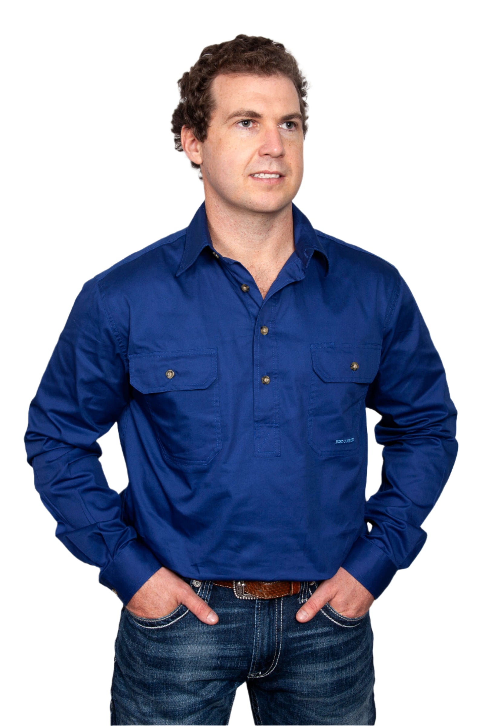 Just Country Men's Cameron L/S Workshirt. A man wearing a blue long-sleeved Just Country workshirt with long tails and double pockets.