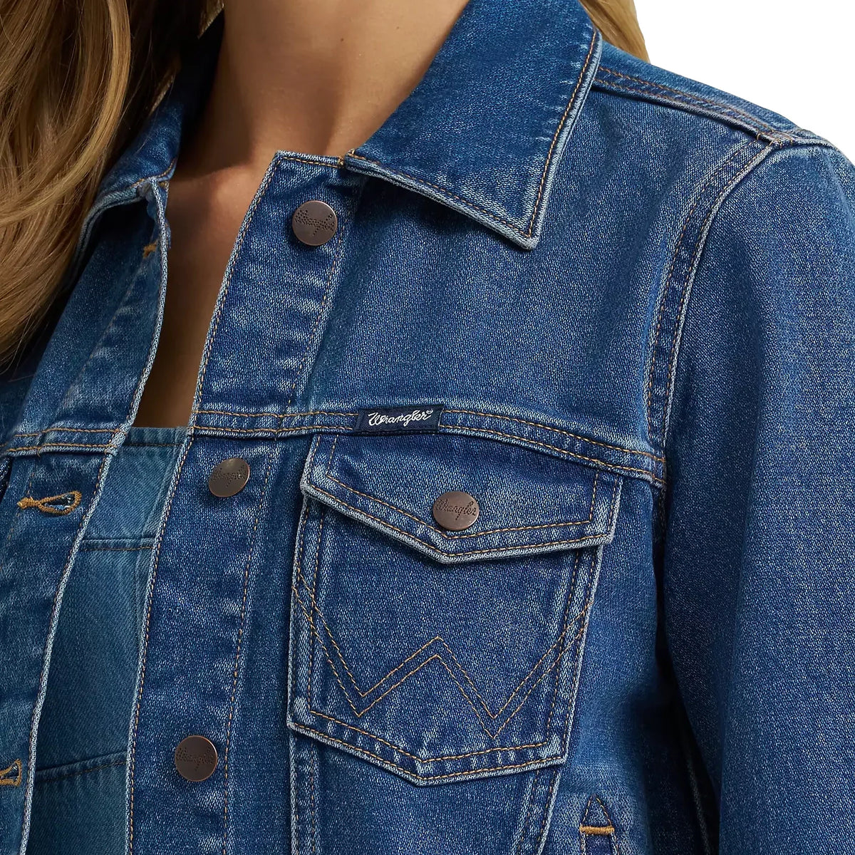 Close-up of a blue denim jacket with a brand logo on the chest pocket.