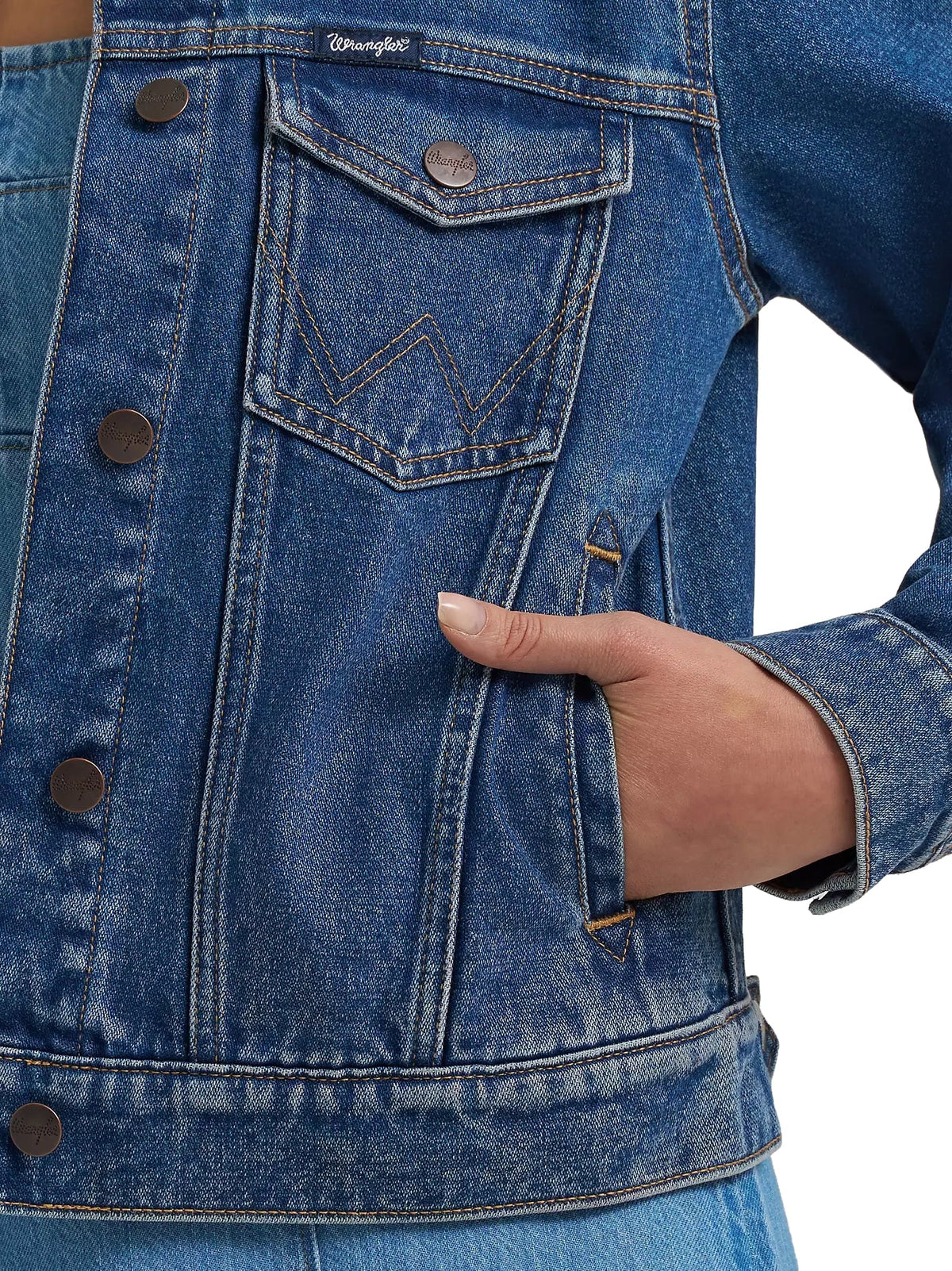 Close-up of a blue denim jacket with a hand in the pocket on a white background