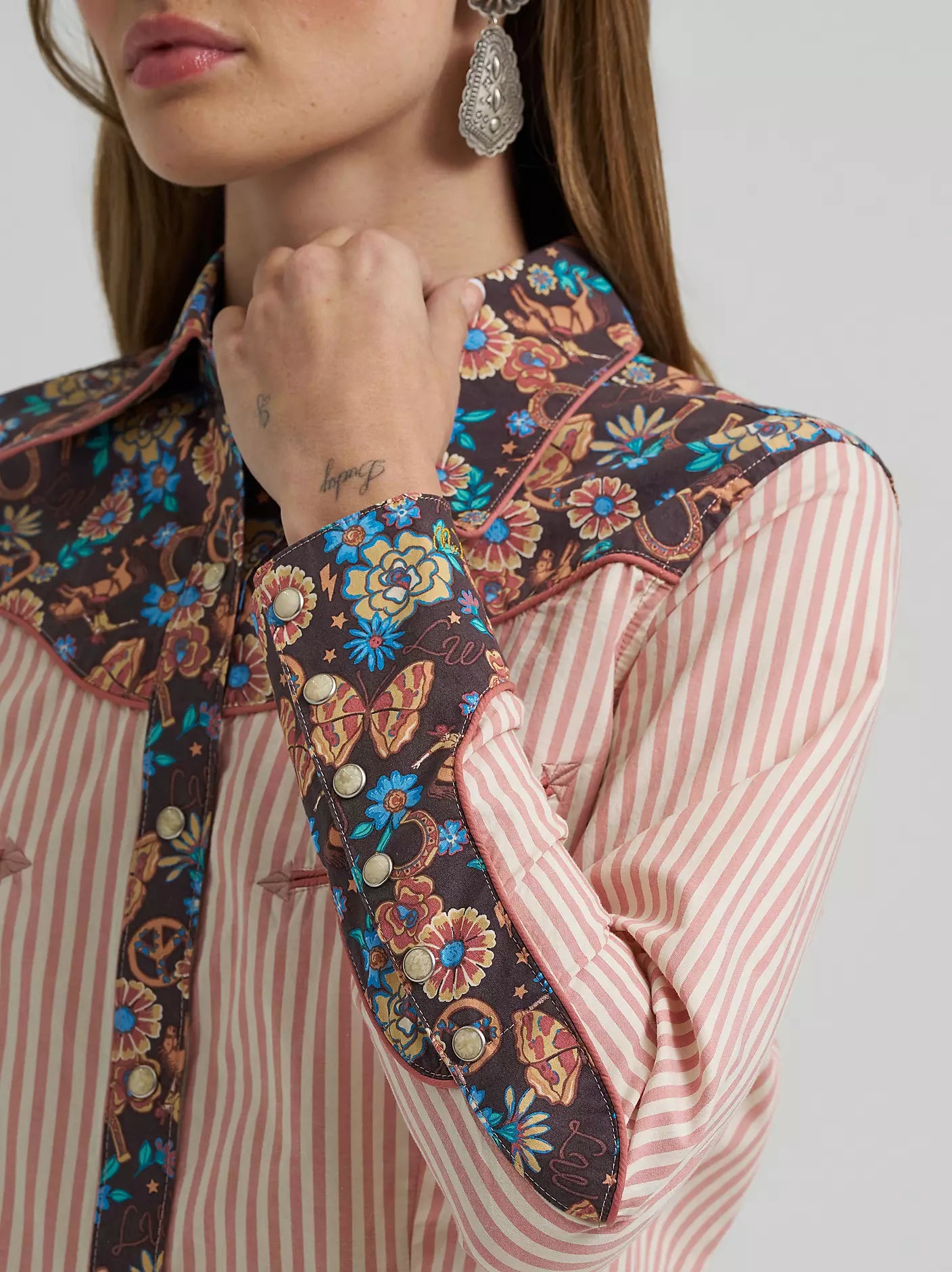 Close-up of a person wearing a floral-patterned shirt with a plain background