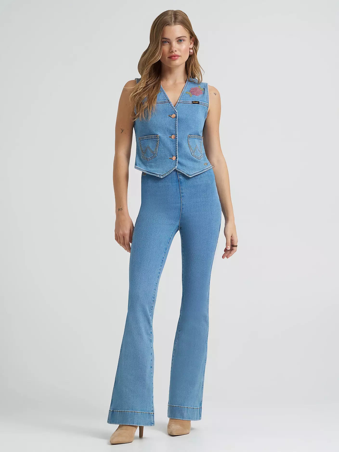 Woman wearing a denim jumpsuit on a white background
