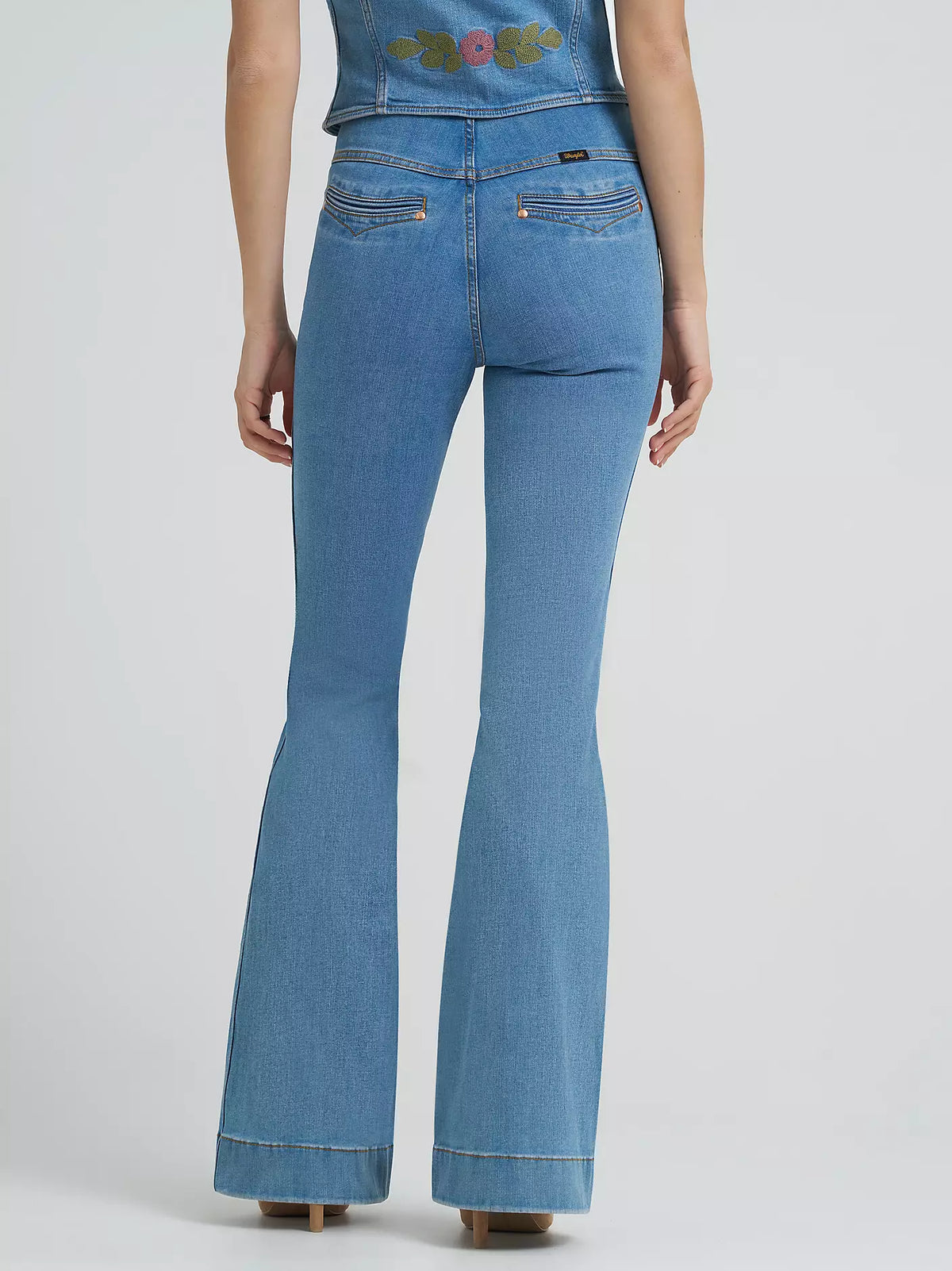 Blue jeans worn by a person on a light gray background