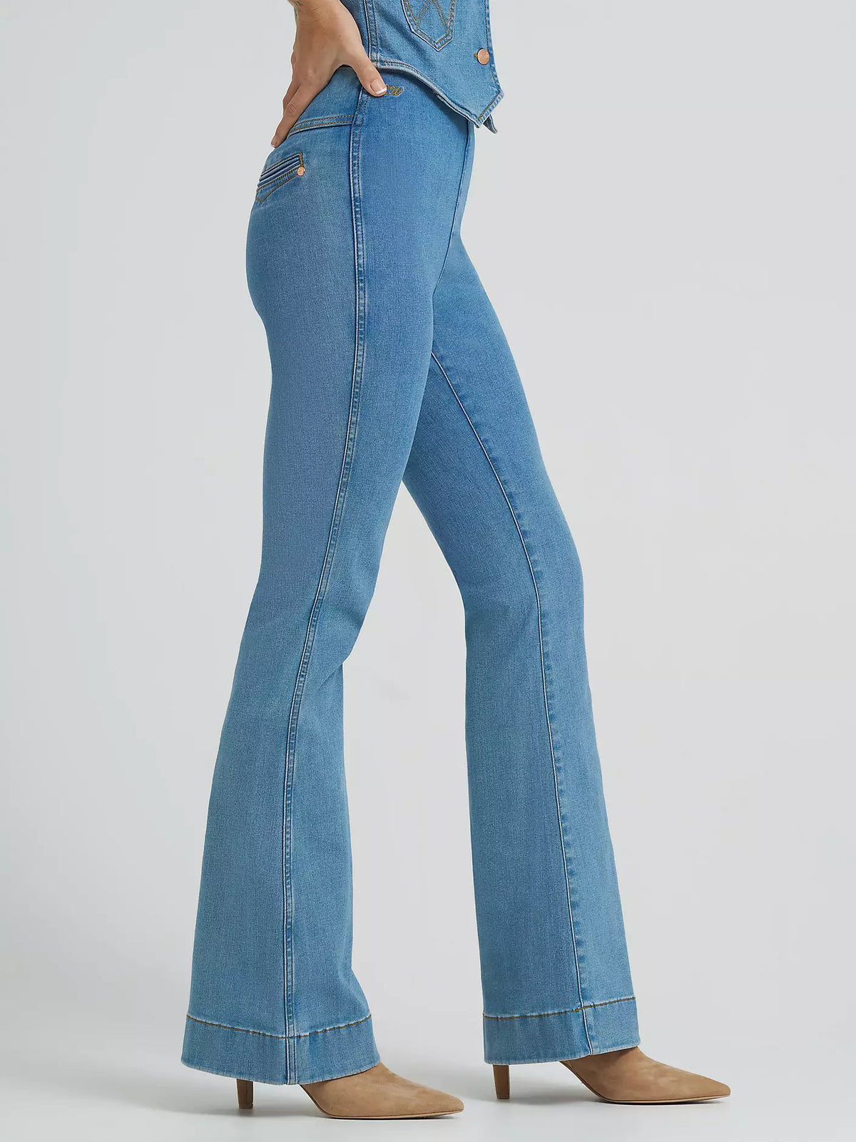 Blue jeans worn by a person on a light gray background
