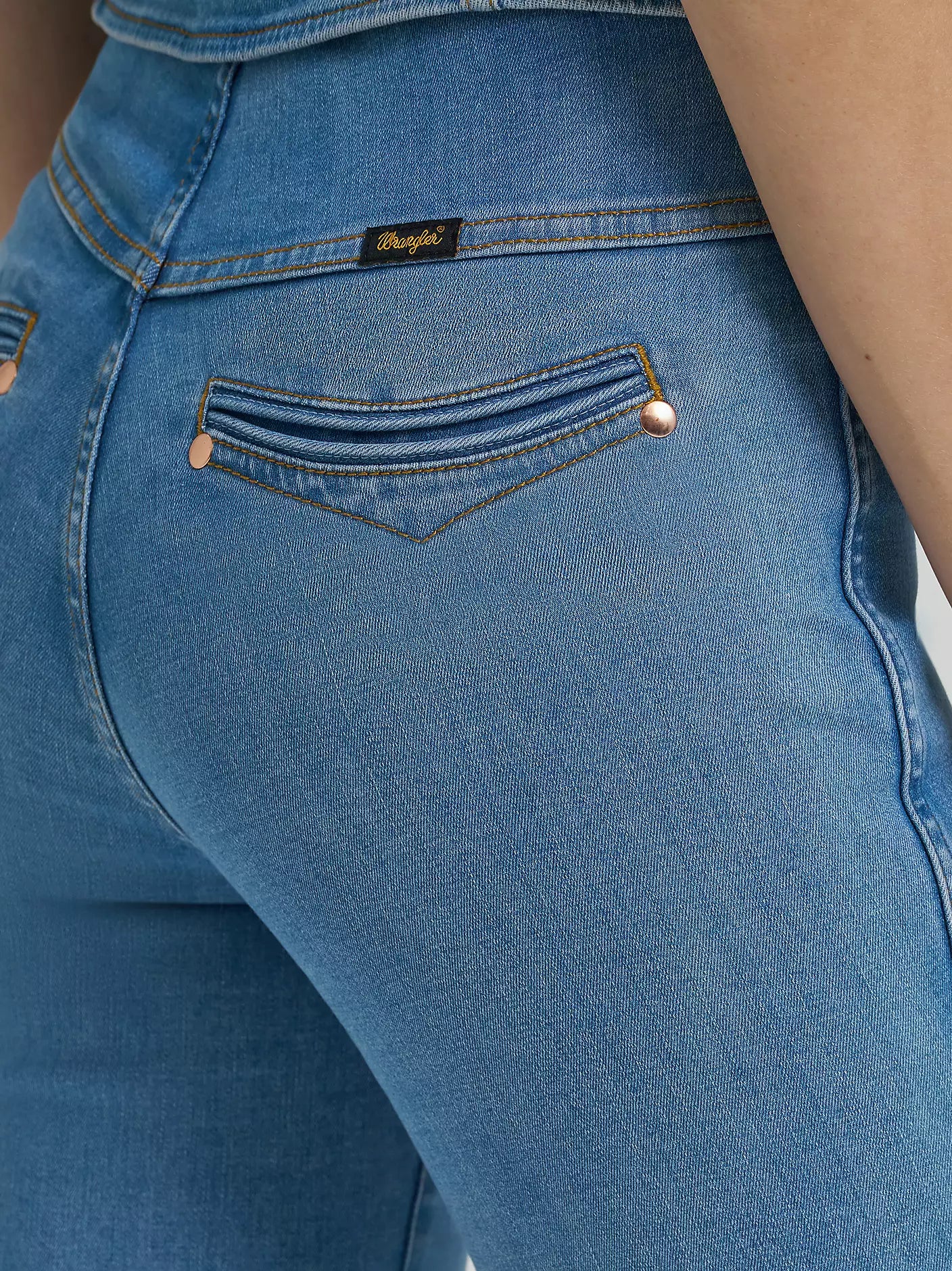 Close-up of blue jeans with a brand label on the pocket.