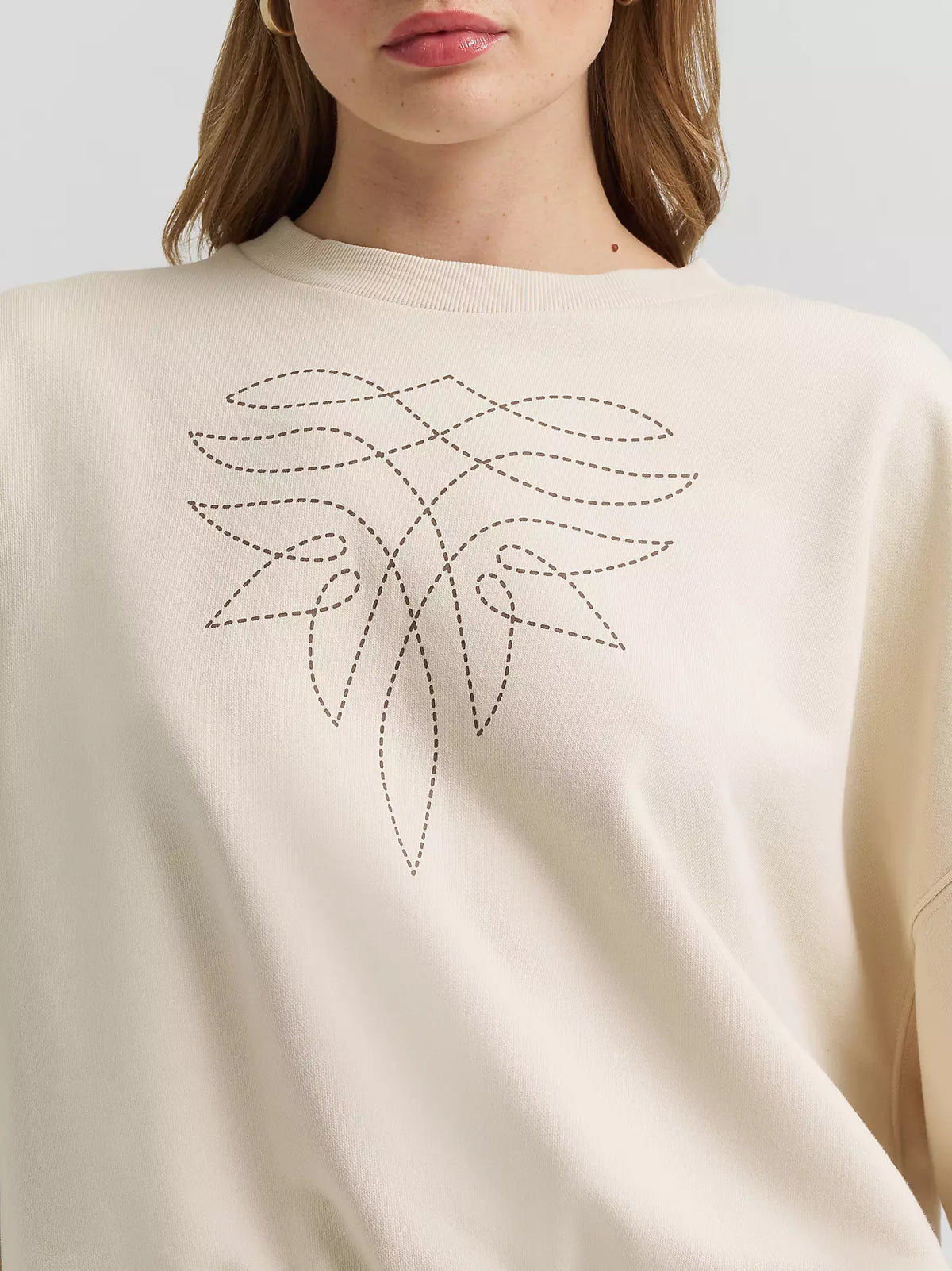 Beige sweater with a decorative leaf pattern on a plain background